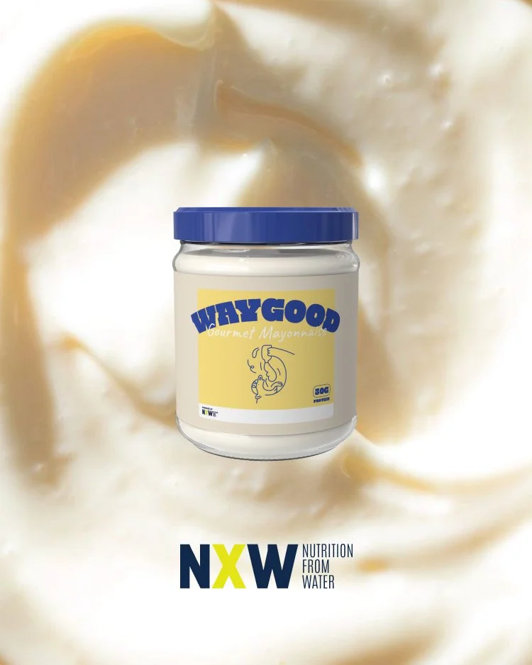 A jar of WayGood Gourmet Mayonnaise with a yellow label featuring a line drawing of a face, placed in front of a beige background with a soft fabric texture.