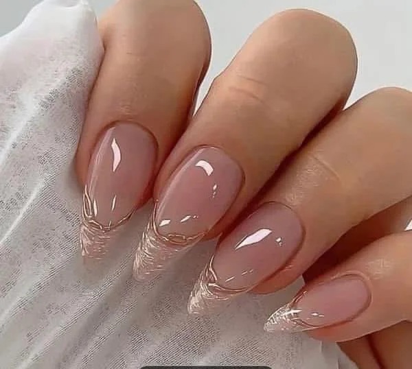 Close-up of a customer's hand with freshly manicured nails featuring clear, shiny polish and elegant pointed tips.