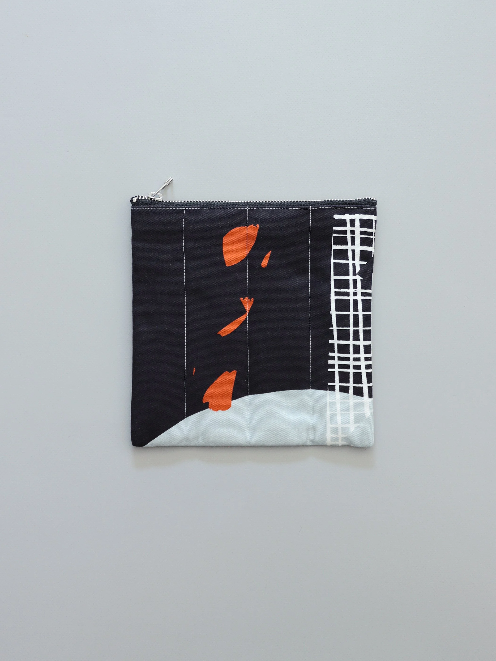 黒地にオレンジのドットと格子模様が映える、和モダンなポーチ｜アセンダダ