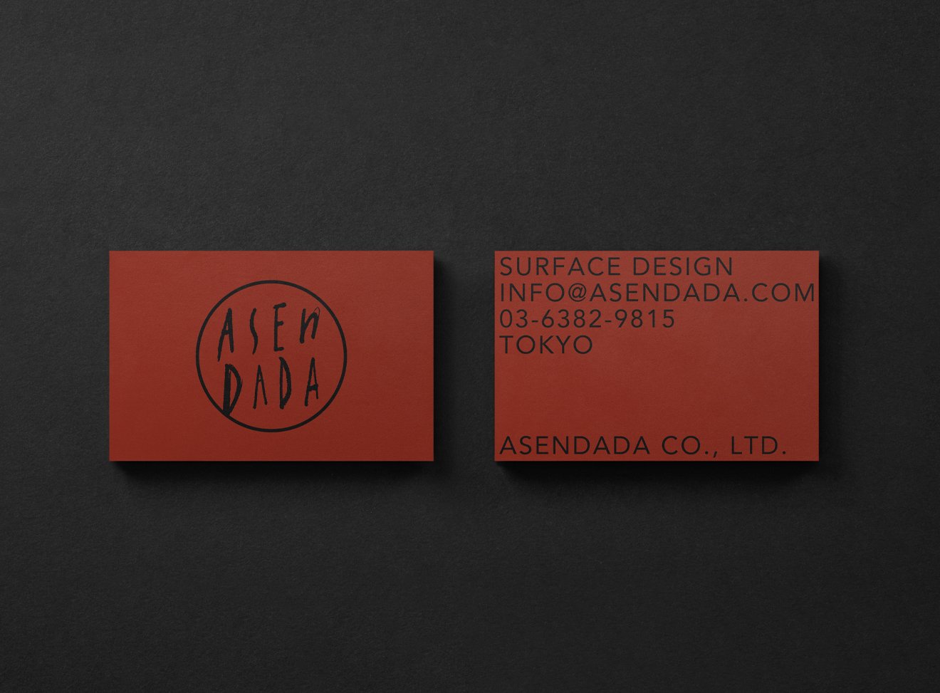 赤色の名刺２枚、左には丸いロゴと「ASEN DADA」の文字、右には連絡先情報と会社名が記載されている個人情報は含まれていません。