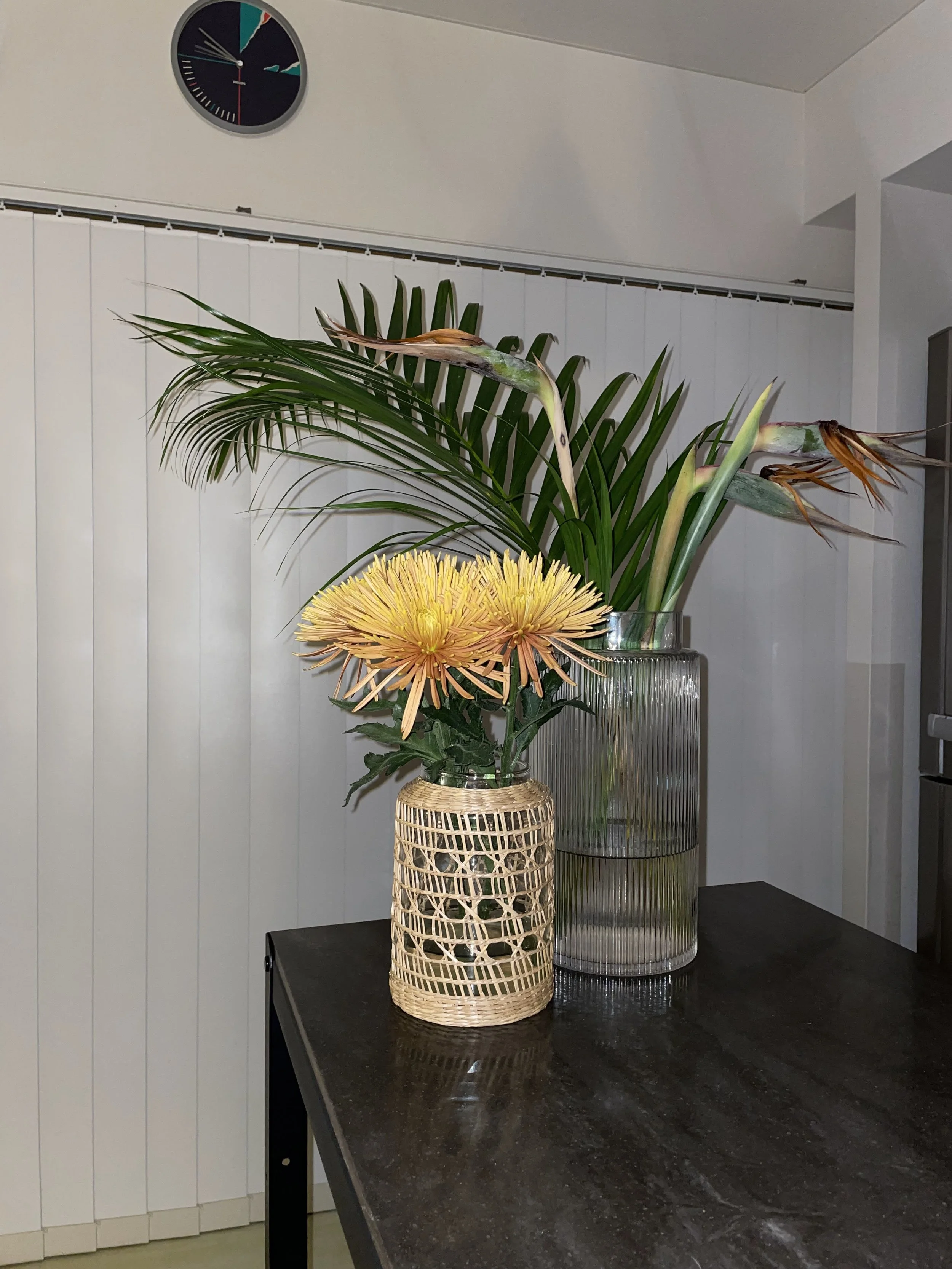 ASENDADA（アセンダダ）のスタジオ記録。今回は、繊細な花びらが美しいオレンジの糸菊と、力強いフォルムのストレリチアを生けました。自然素材のラタンベースが、都会的なインテリアに温かみを添えます。お花の種類を限定せず、自由な感性で切り花を楽しむ「Studio flower」。ボタニカルライフを取り入れたおしゃれな空間づくりに。