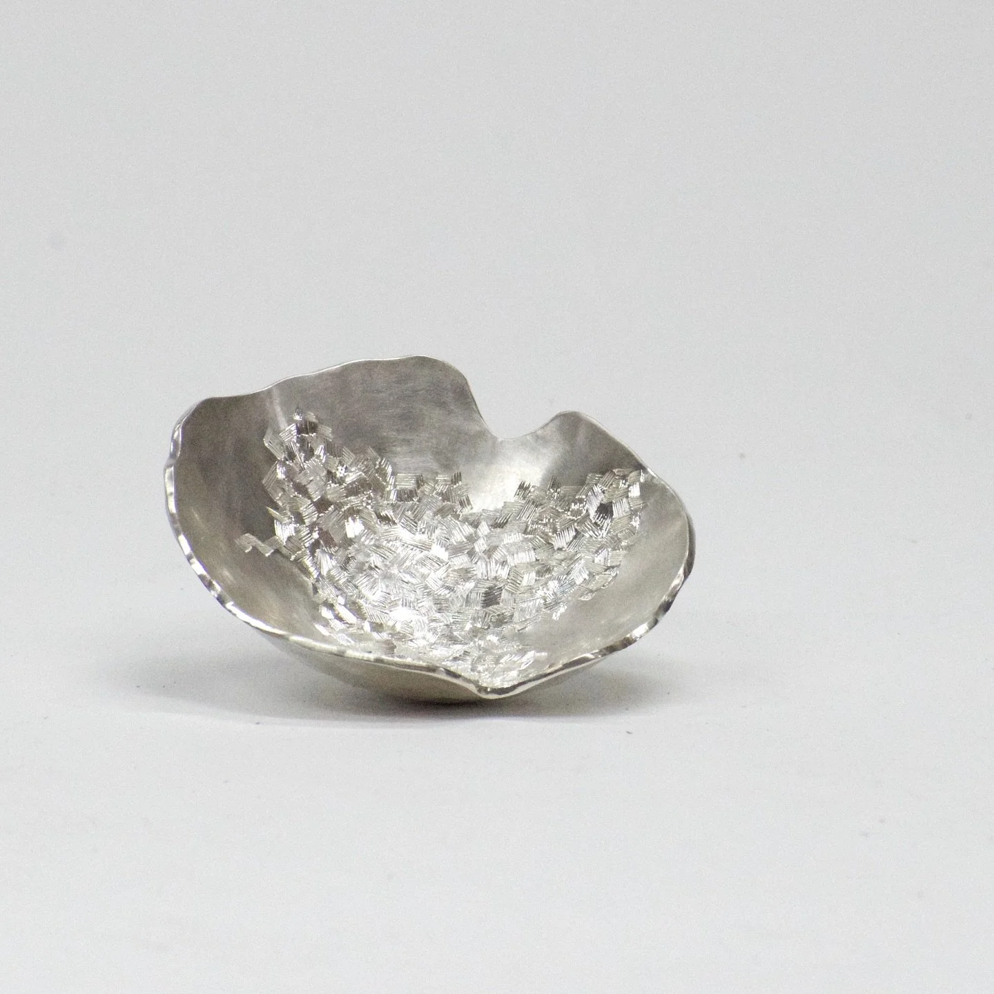 Raised from a single sheet of silver, this vessel takes form through hundreds of hammer blows. Its surface carries hand-engraved textures that scatter the light.
Hand raised. Hand engraved. &pound;495.

#Silversmithing #HandEngraving #HandRaised #Con