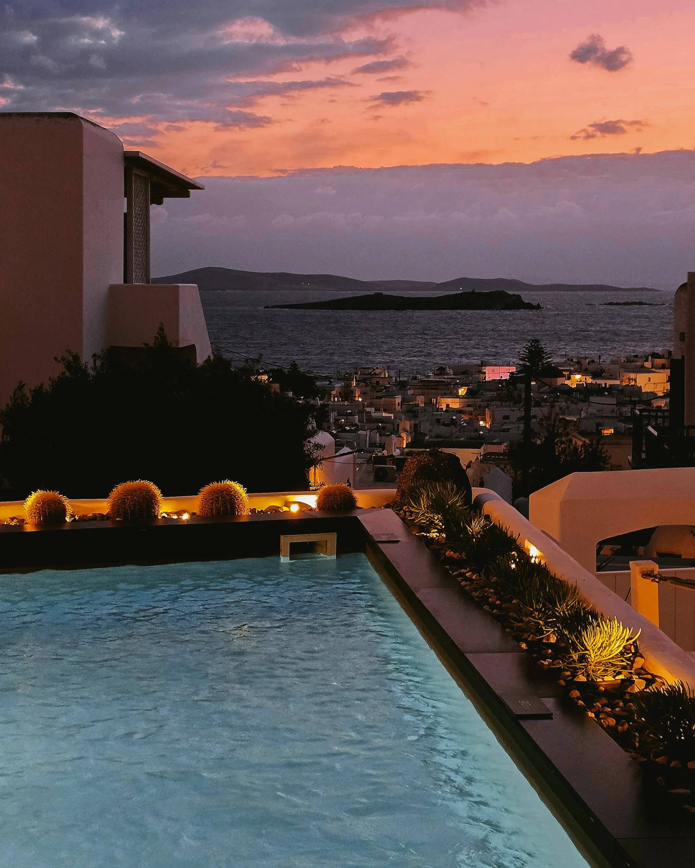 Sunset jacuzzi experience with panoramic sea views and the illuminated skyline of Mykonos after dusk