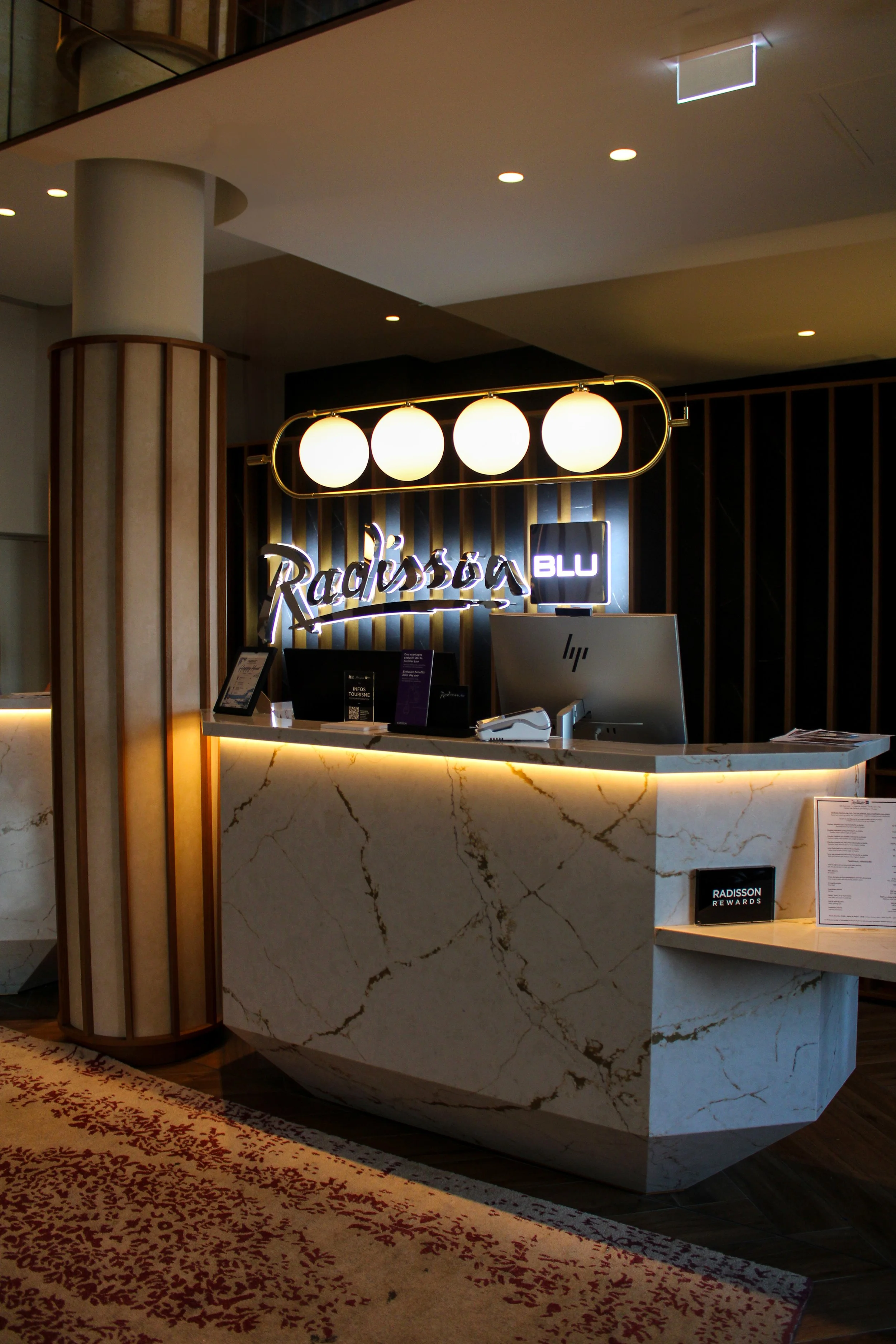 Modern reception desk with elegant marble finishes and contemporary lighting