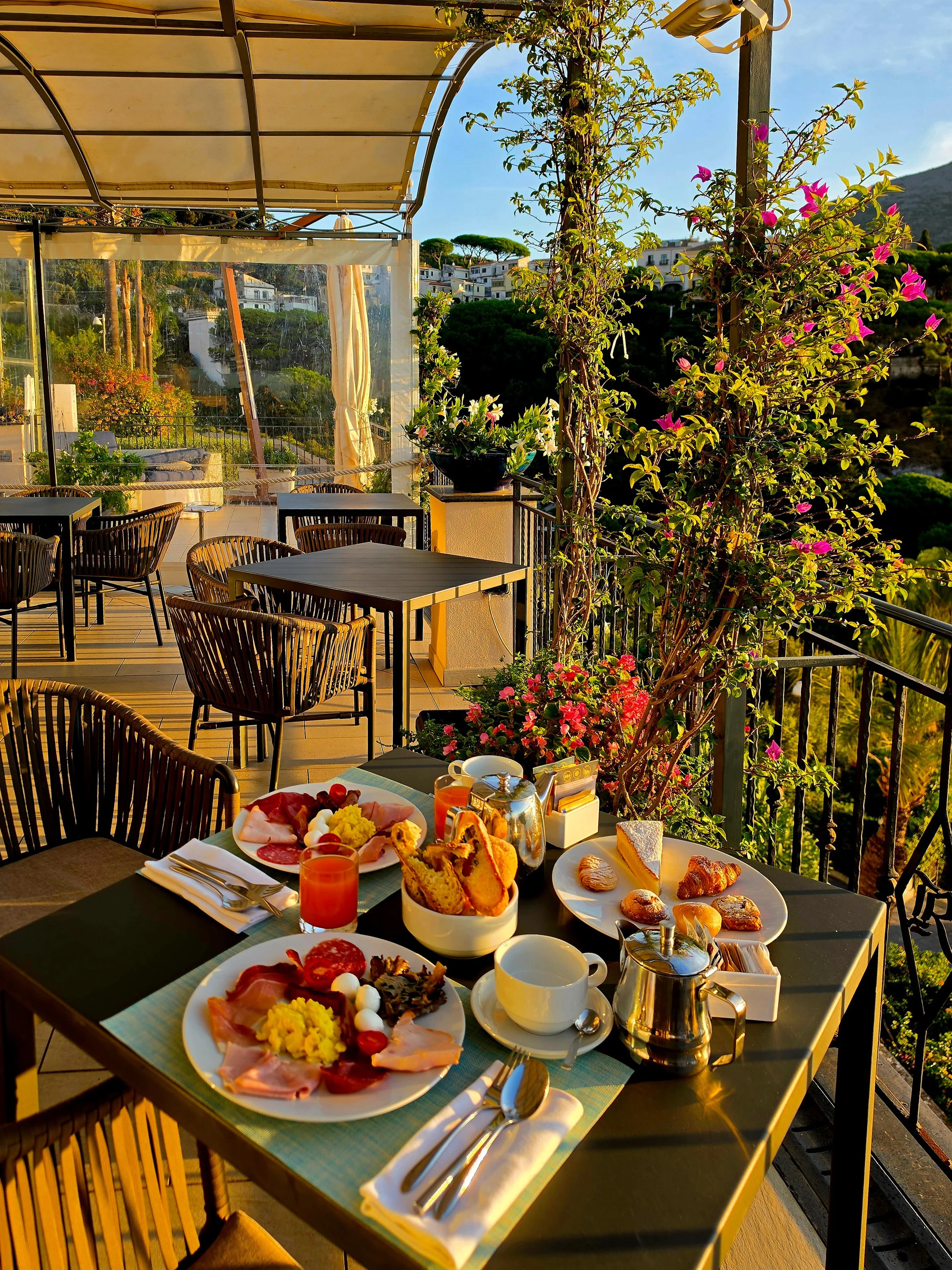 Breakfast served on a panoramic terrace surrounded by flowers and Mediterranean greenery