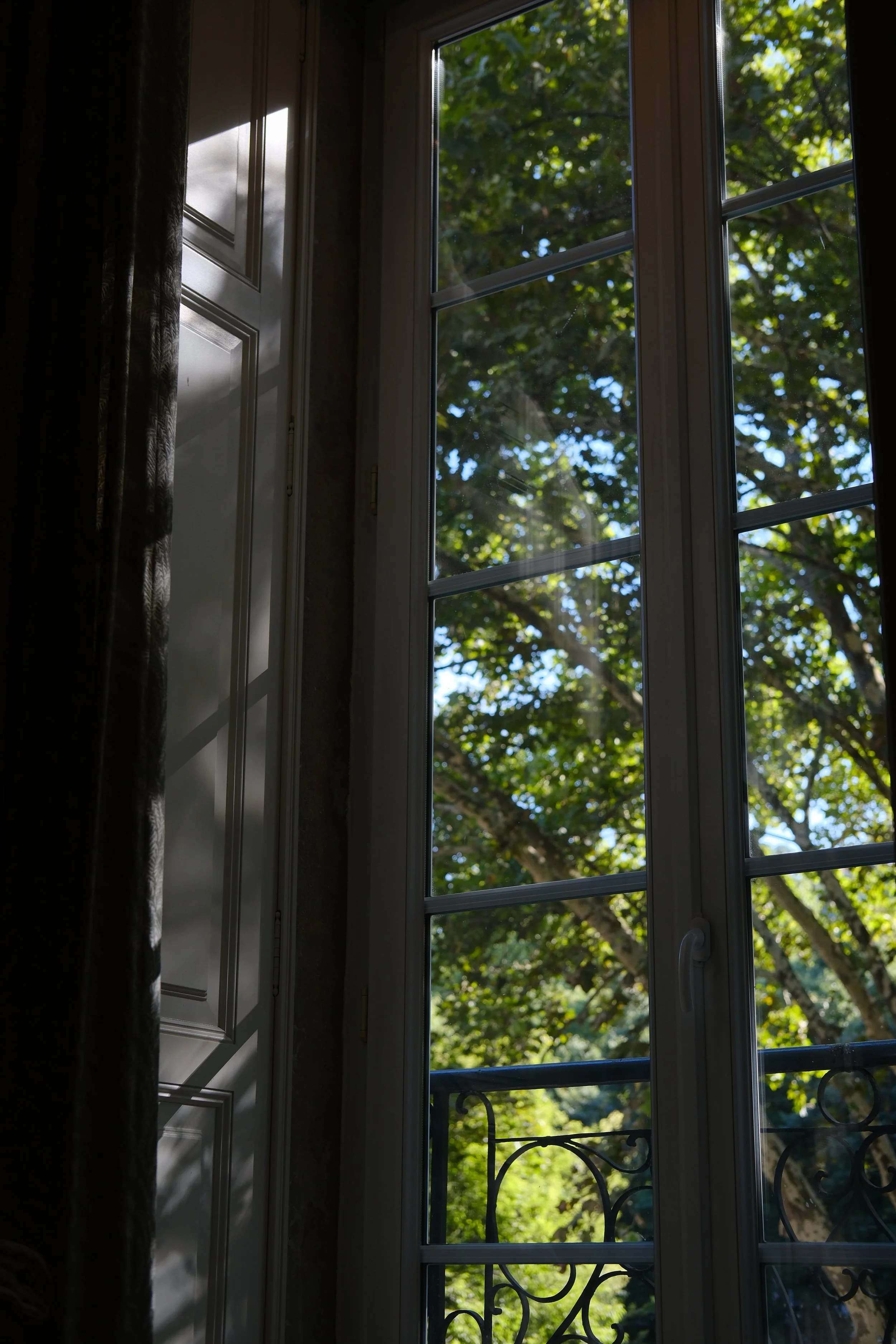 Large windows opening to peaceful views of Lisbon's tree lined boulevard