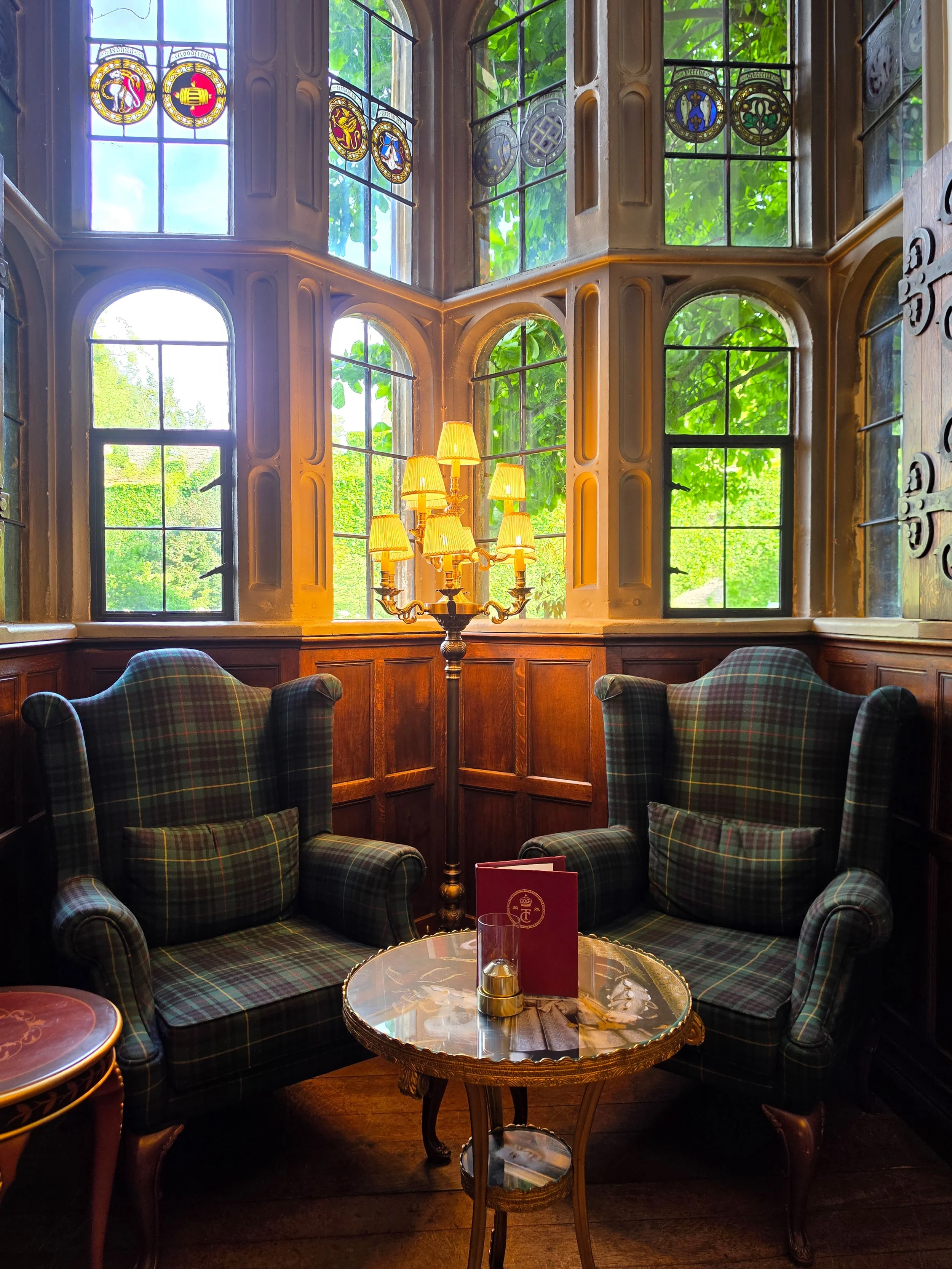Cosy reading corner beside stained glass windows with classic armchairs and heritage architecture