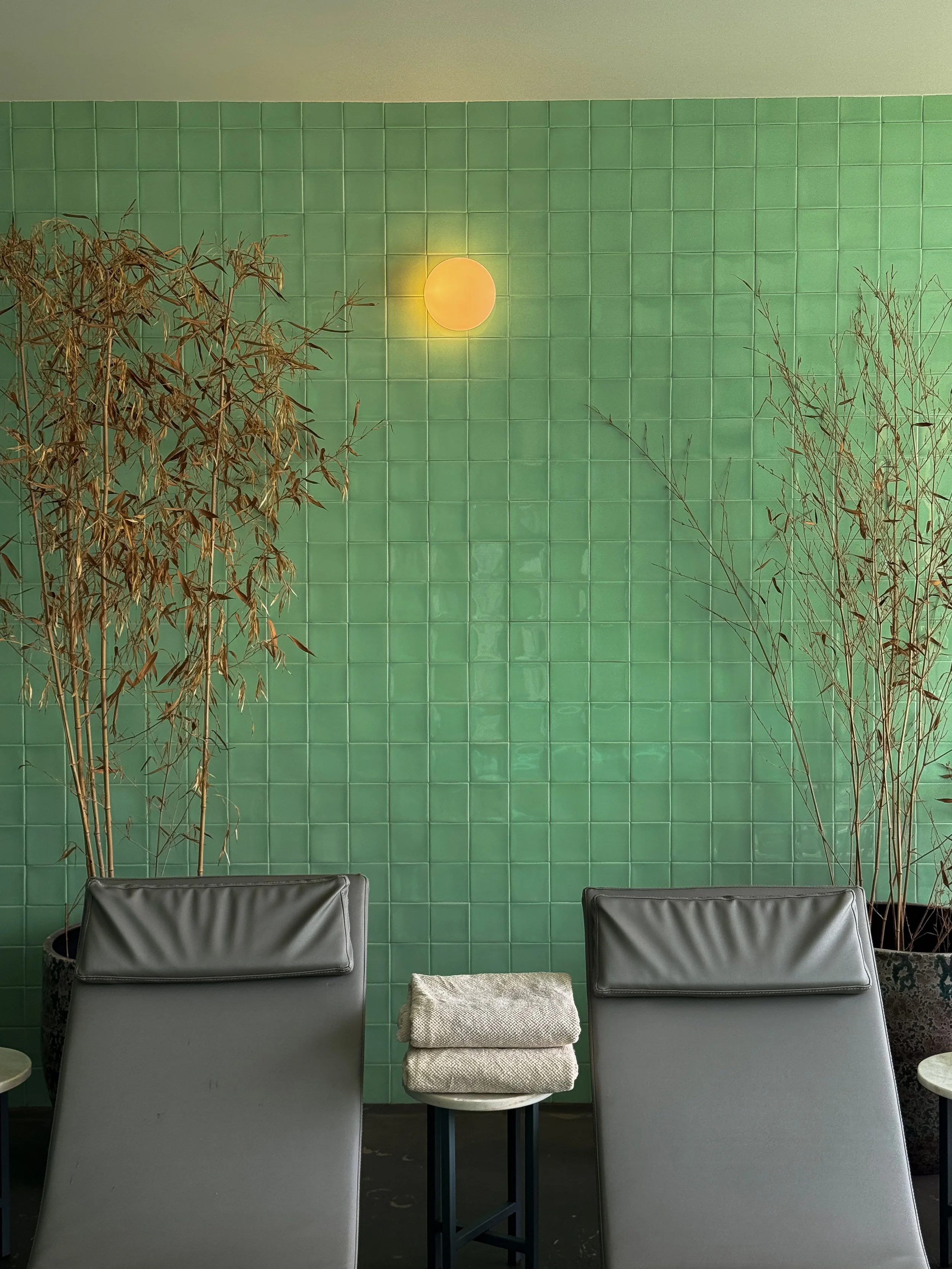 Peaceful spa relaxation area featuring emerald green tiles and contemporary wellness design