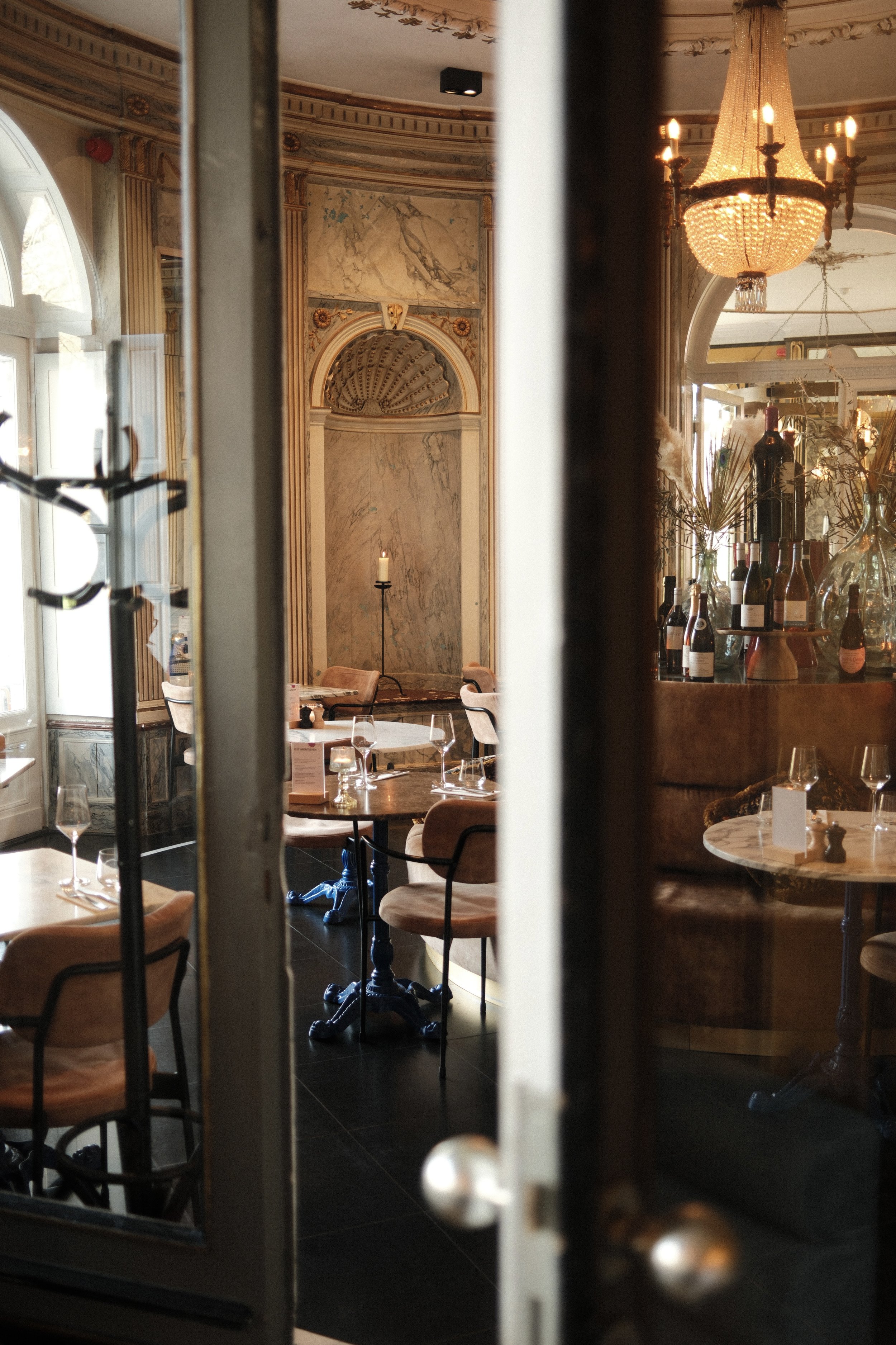 Elegant dining room with marble walls, chandeliers, and warm candlelight creating a refined historic atmosphere, Château St. Gerlach – Vaeshartelt Maastricht.