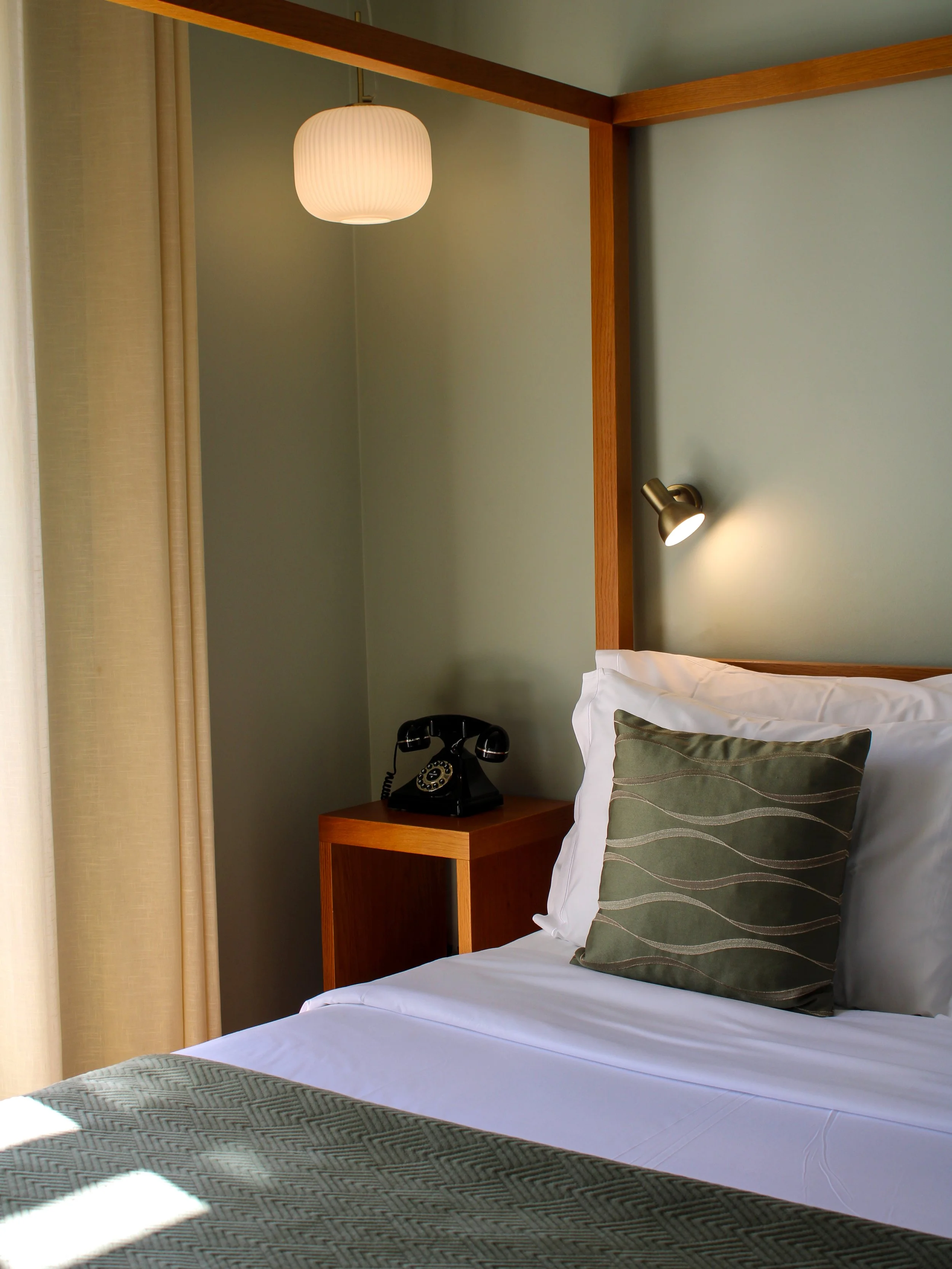 Elegant boutique guest room with canopy bed, soft natural light, and timeless contemporary design