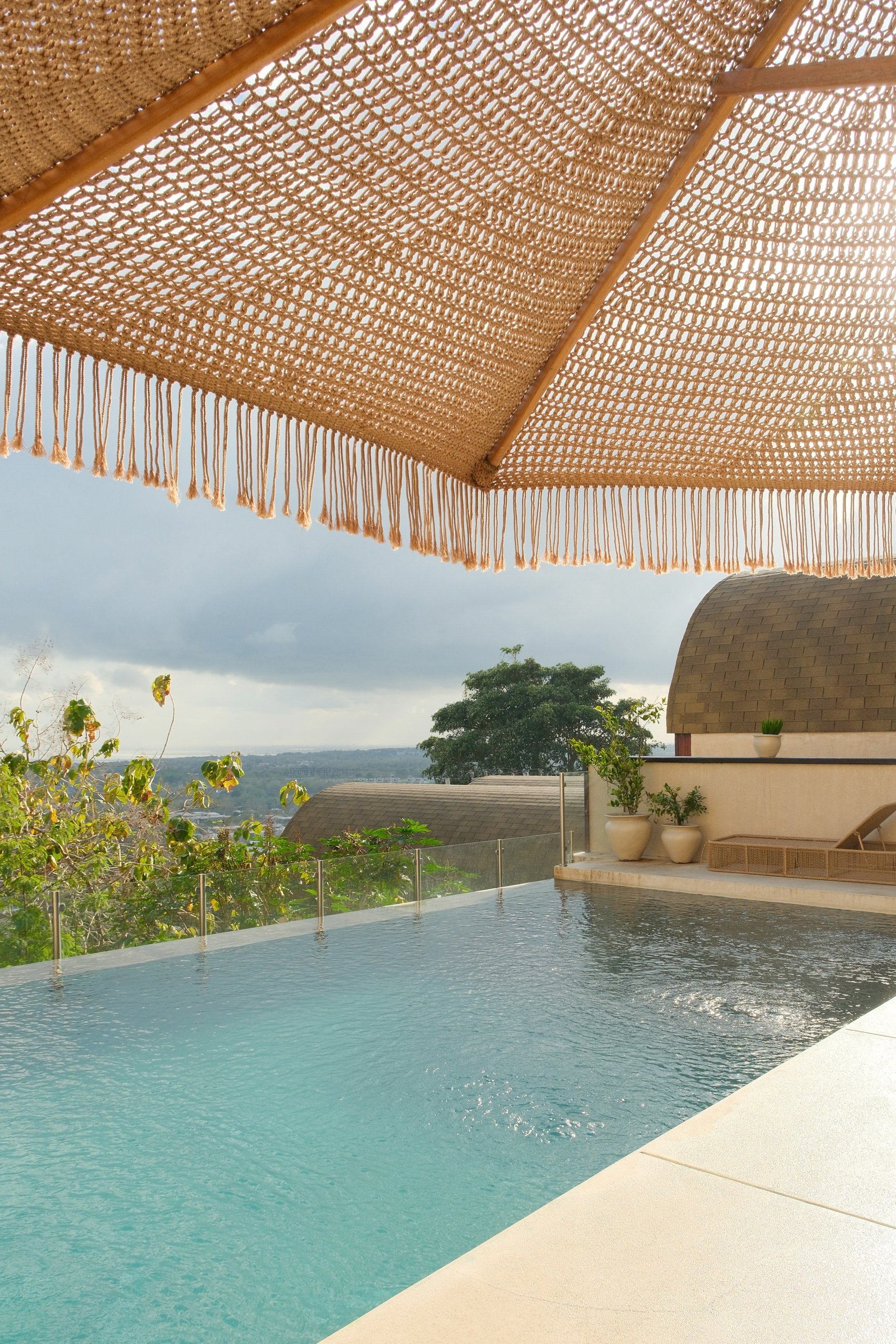 Infinity pool overlooking lush landscapes and the distant ocean horizon