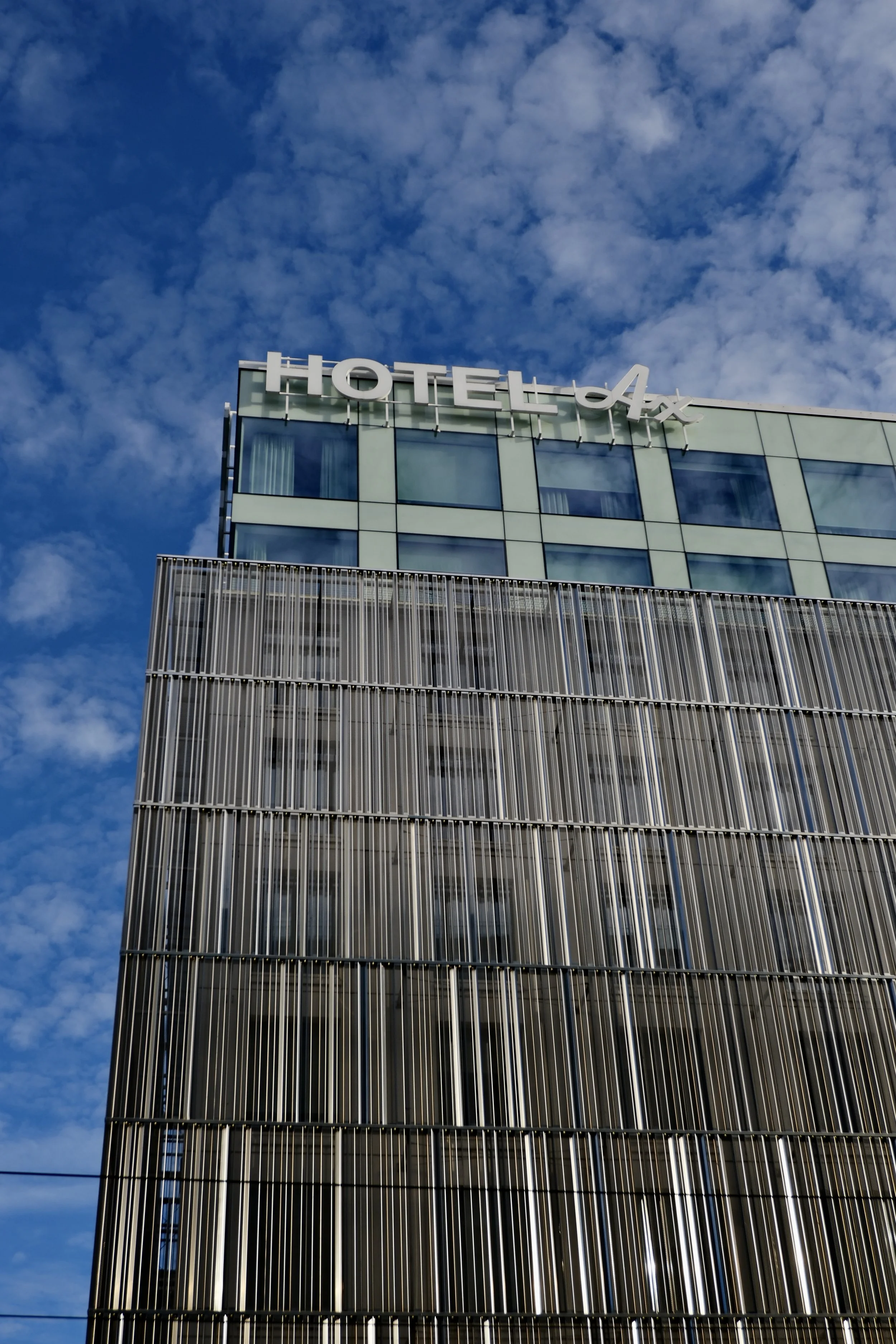 Modern Hotel AX façade with striking contemporary architecture beneath a blue sky