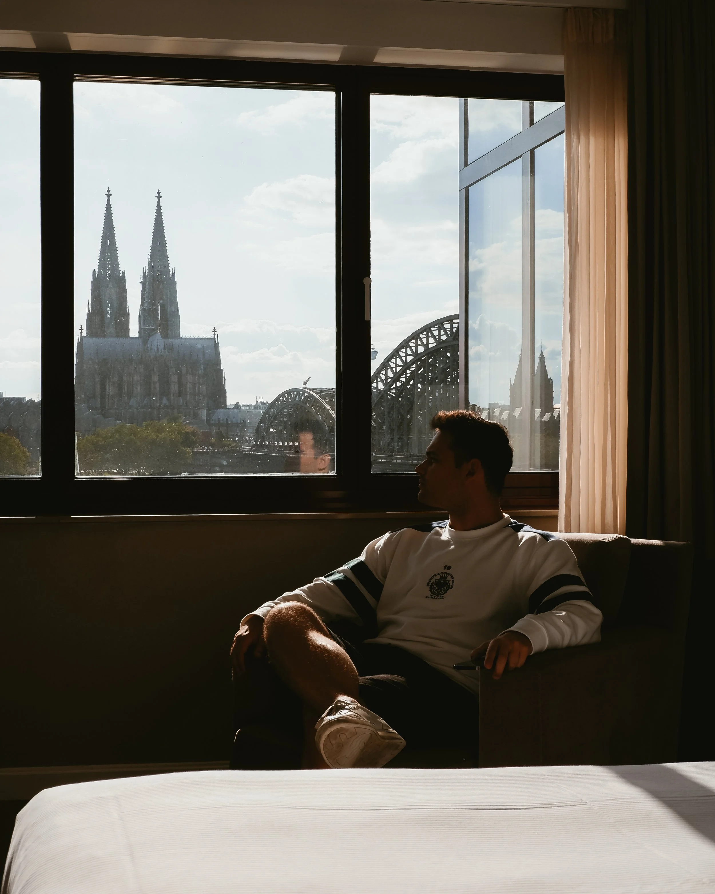 Relaxing moment overlooking Cologne’s skyline from a luxury hotel room with cathedral views