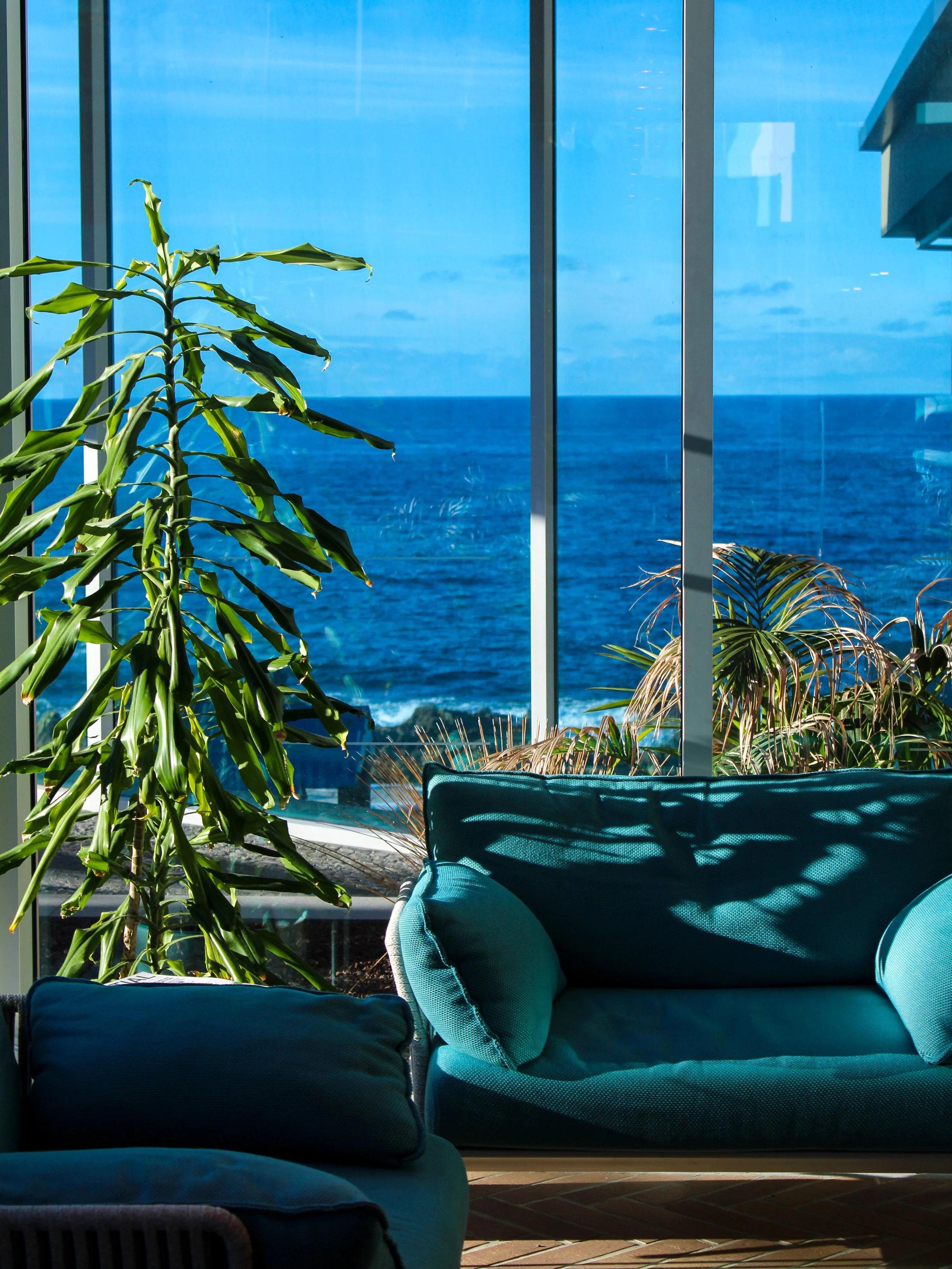 Elegant lounge overlooking the ocean through floor-to-ceiling windows filled with natural light