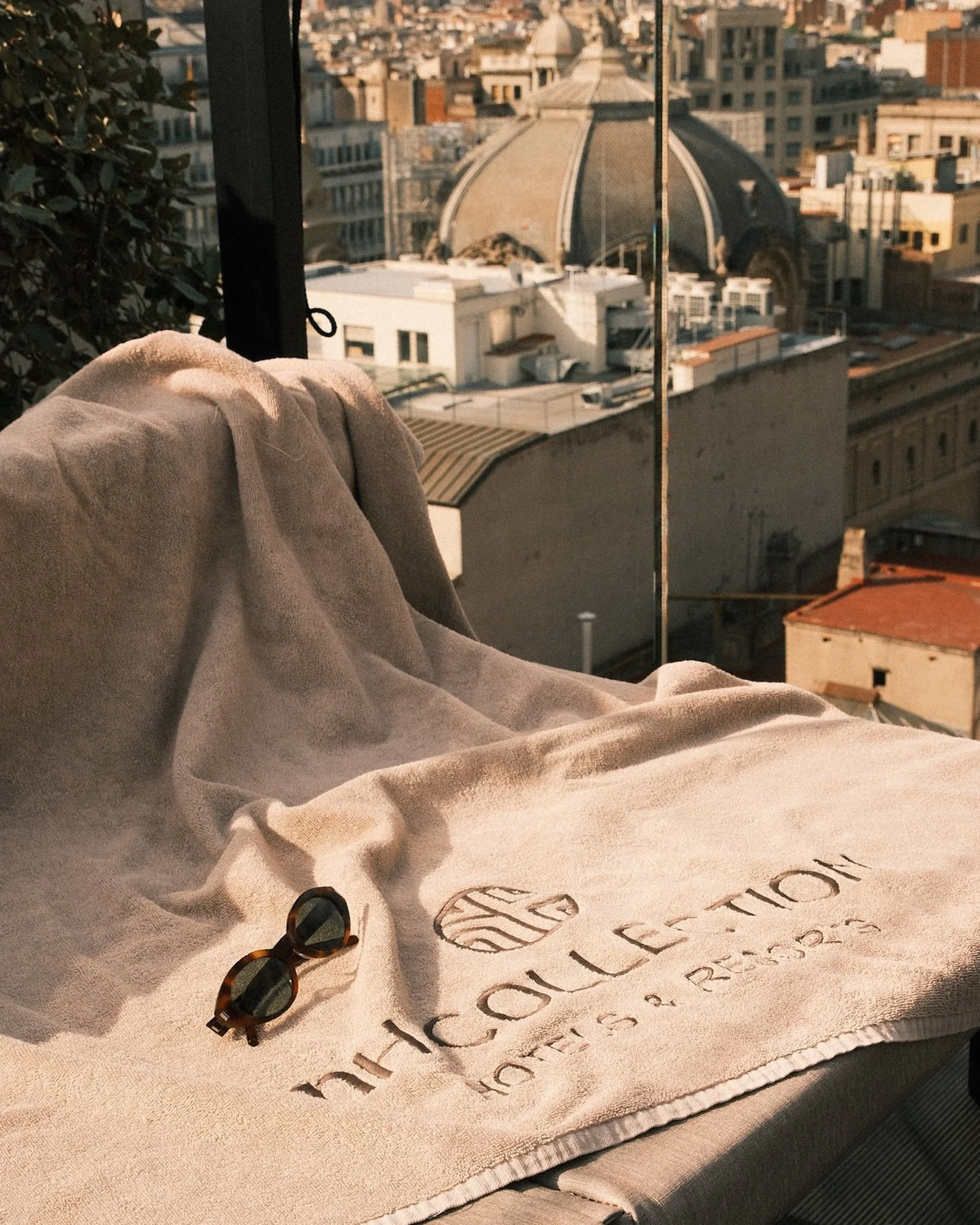 Luxury rooftop lounge with embroidered NH Collection towel and city views