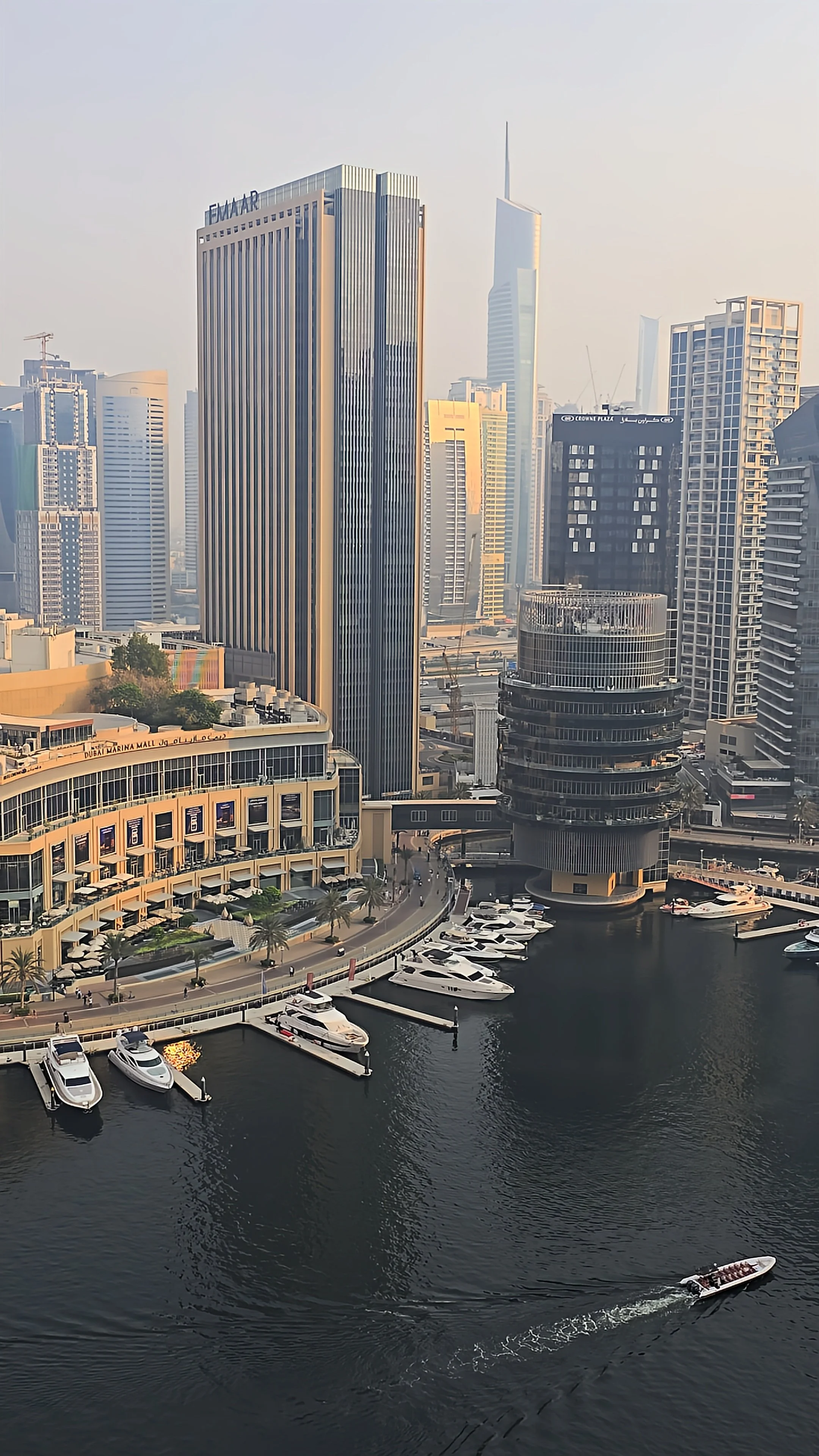 Panoramic view of Dubai Marina featuring luxury yachts, waterfront buildings, and the surrounding city skyline