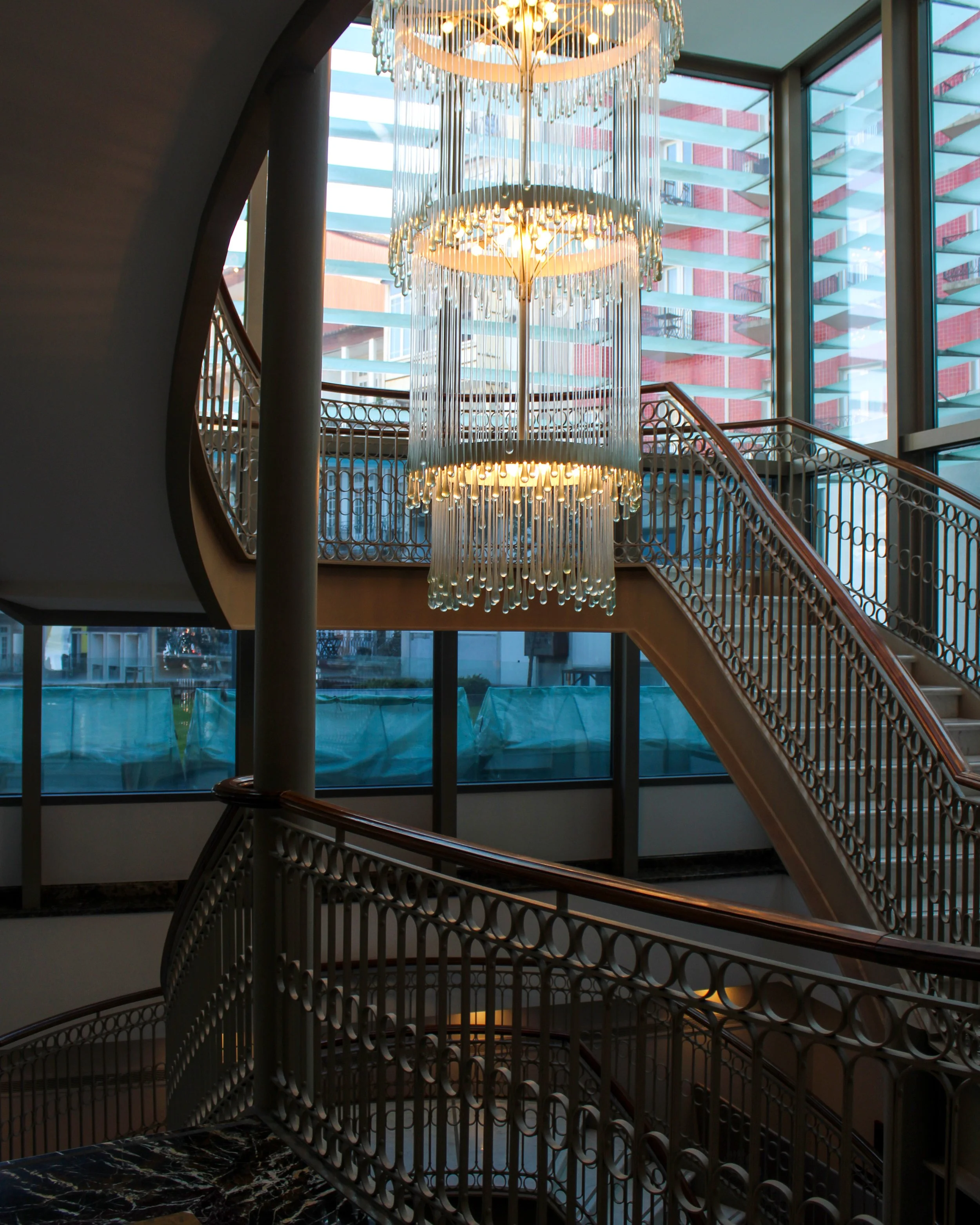 Grand staircase illuminated by cascading contemporary chandeliers