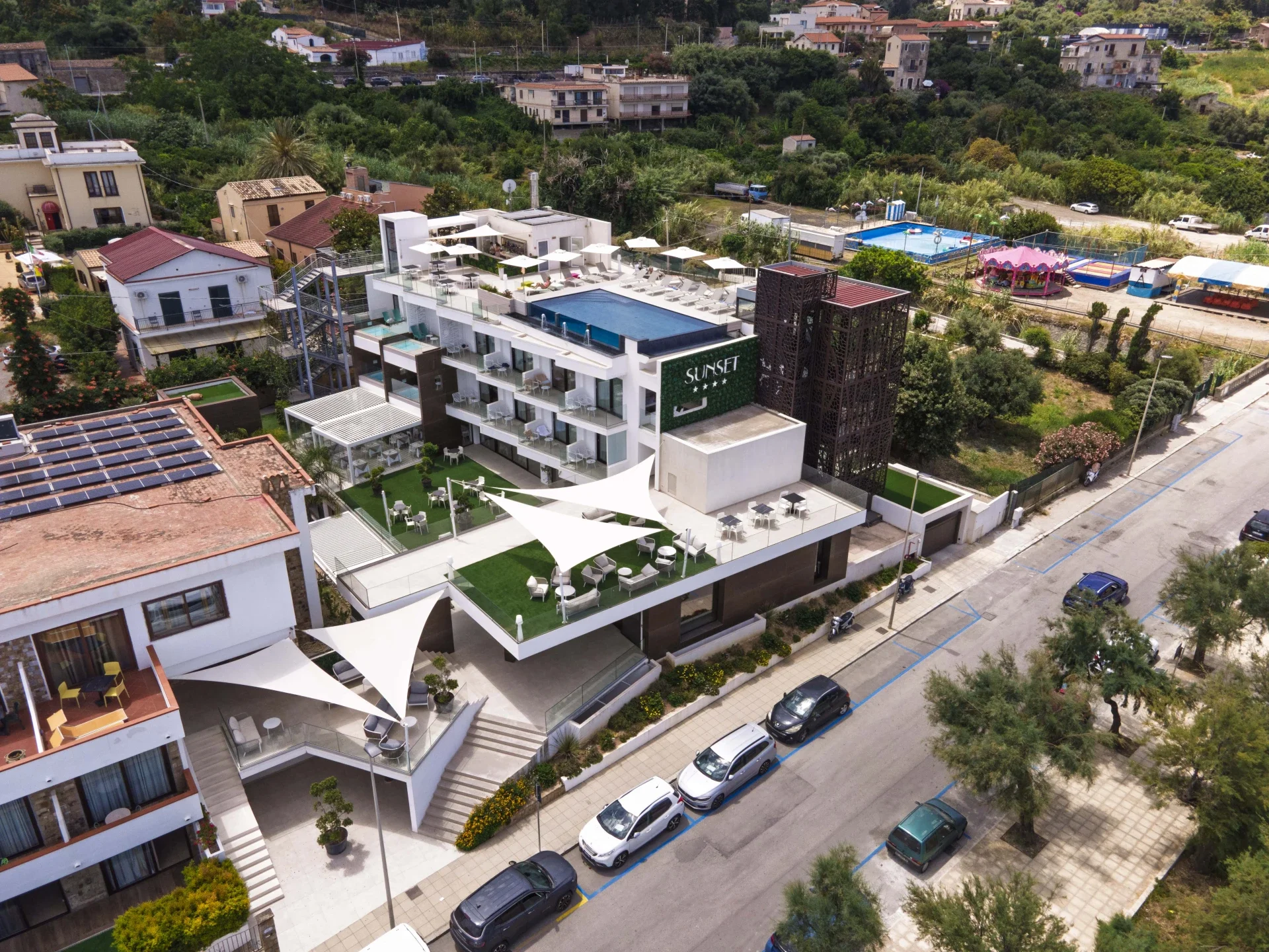 Aerial view of Sunset Hotel Cefalù with rooftop pool and modern architecture