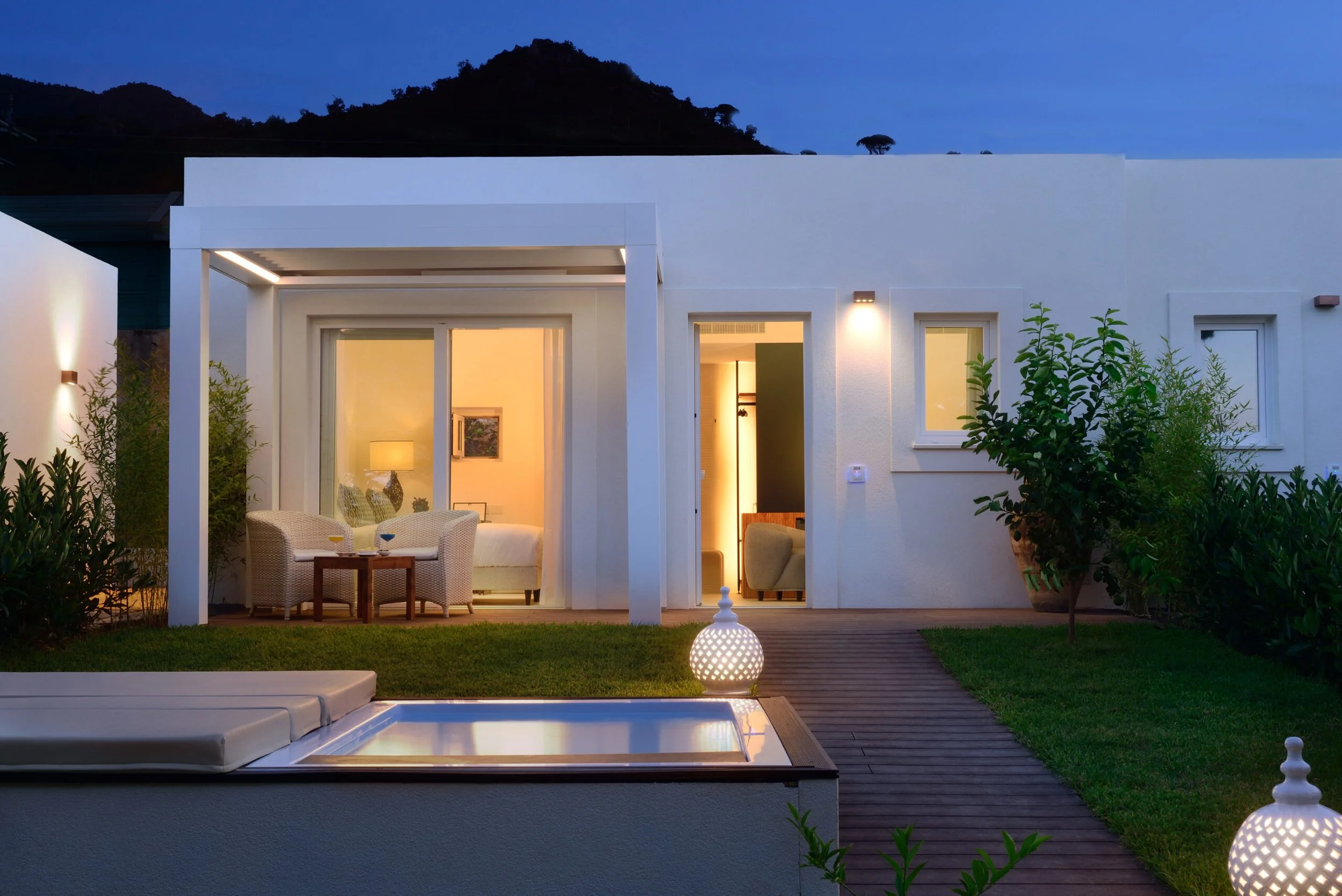 Private villa with plunge pool lit at dusk at Le Calette Hotel, Cefalù, Italy