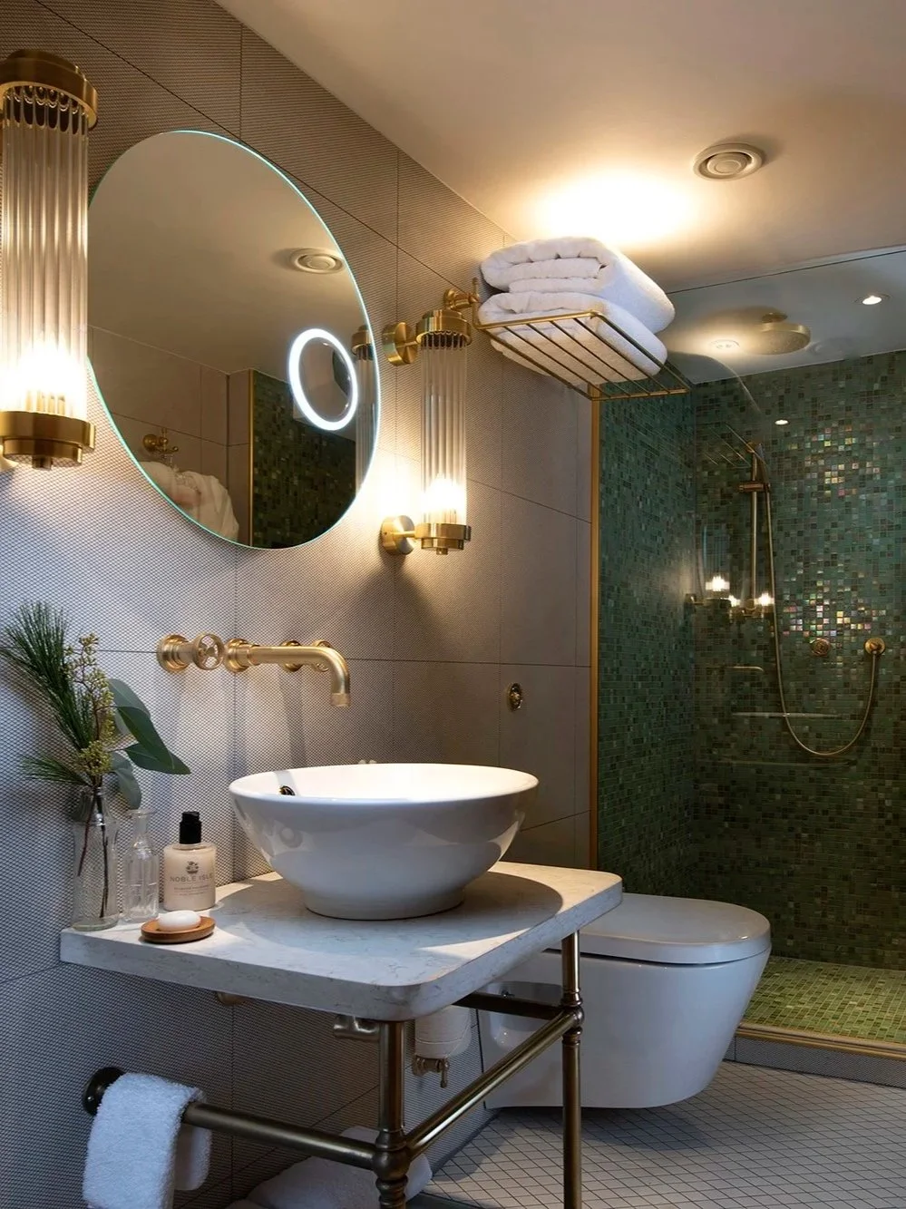 Elegant marble bathroom with brass accents and walk-in rain shower aboard Fingal Hotel