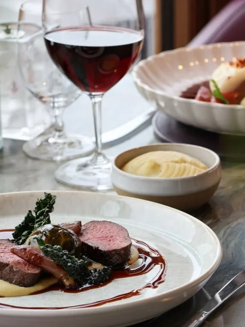 Fine dining featuring gourmet Scottish cuisine paired with premium red wine aboard Fingal Hotel