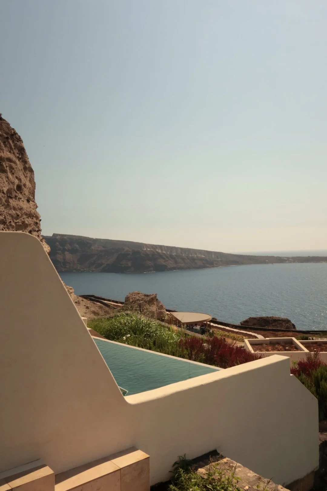 Private infinity pool with uninterrupted caldera views framed by elegant Cycladic architecture and natural surroundings