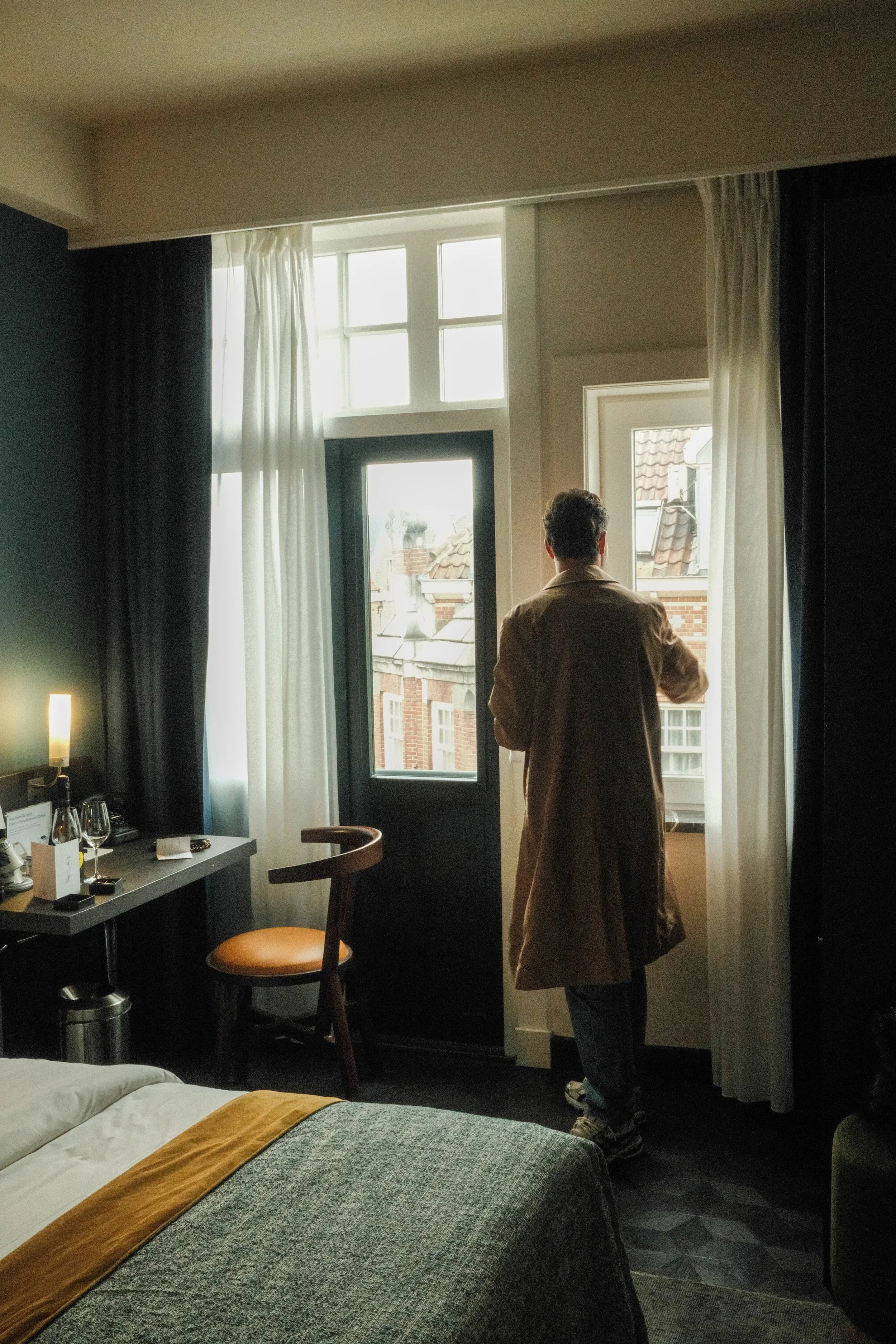 Guest overlooking Amsterdam from an elegant room filled with natural daylight