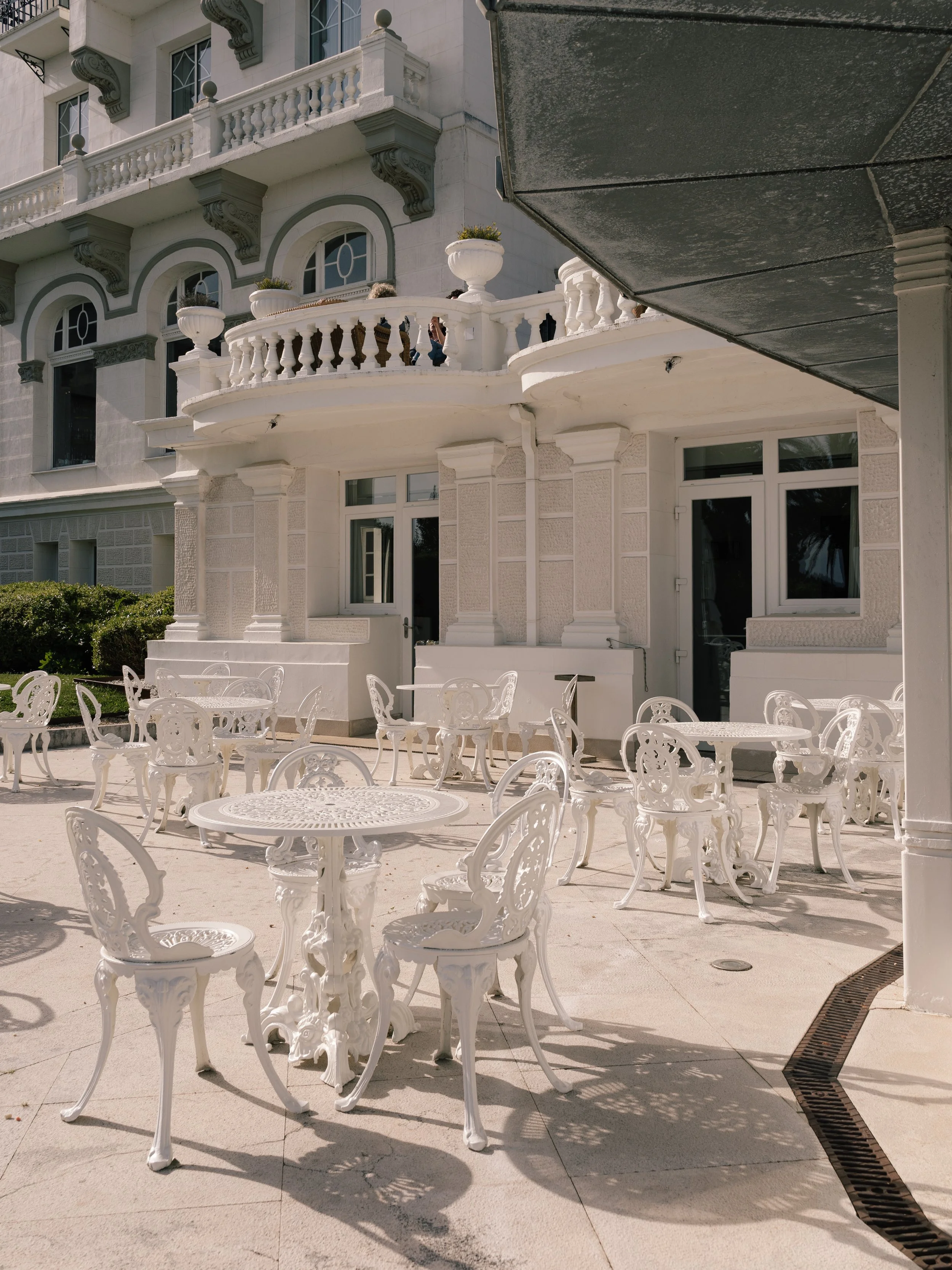 Elegant outdoor terrace with ornate white furniture and historic architecture