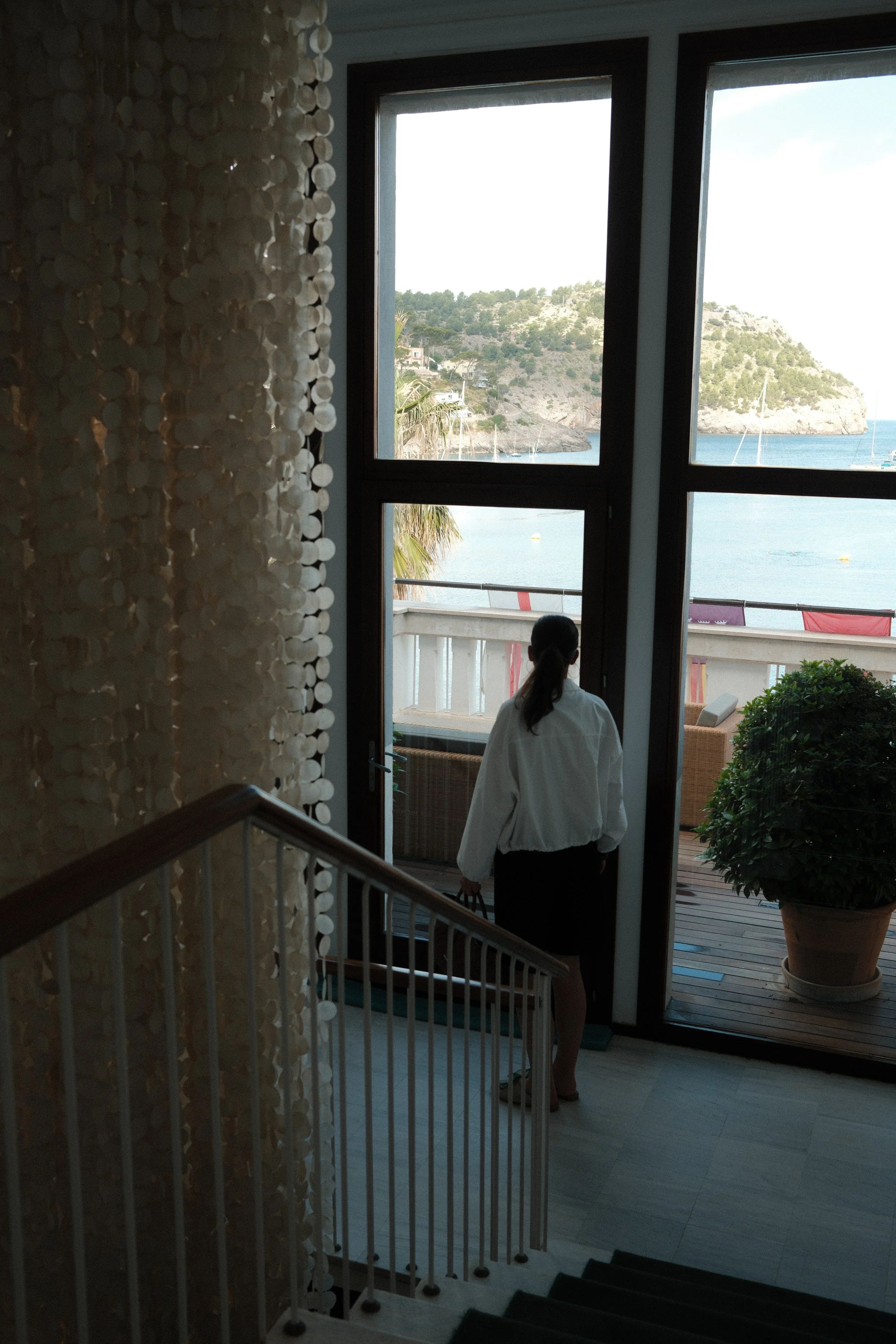 Light-filled staircase leading to a sea-view terrace overlooking the Mediterranean coastline