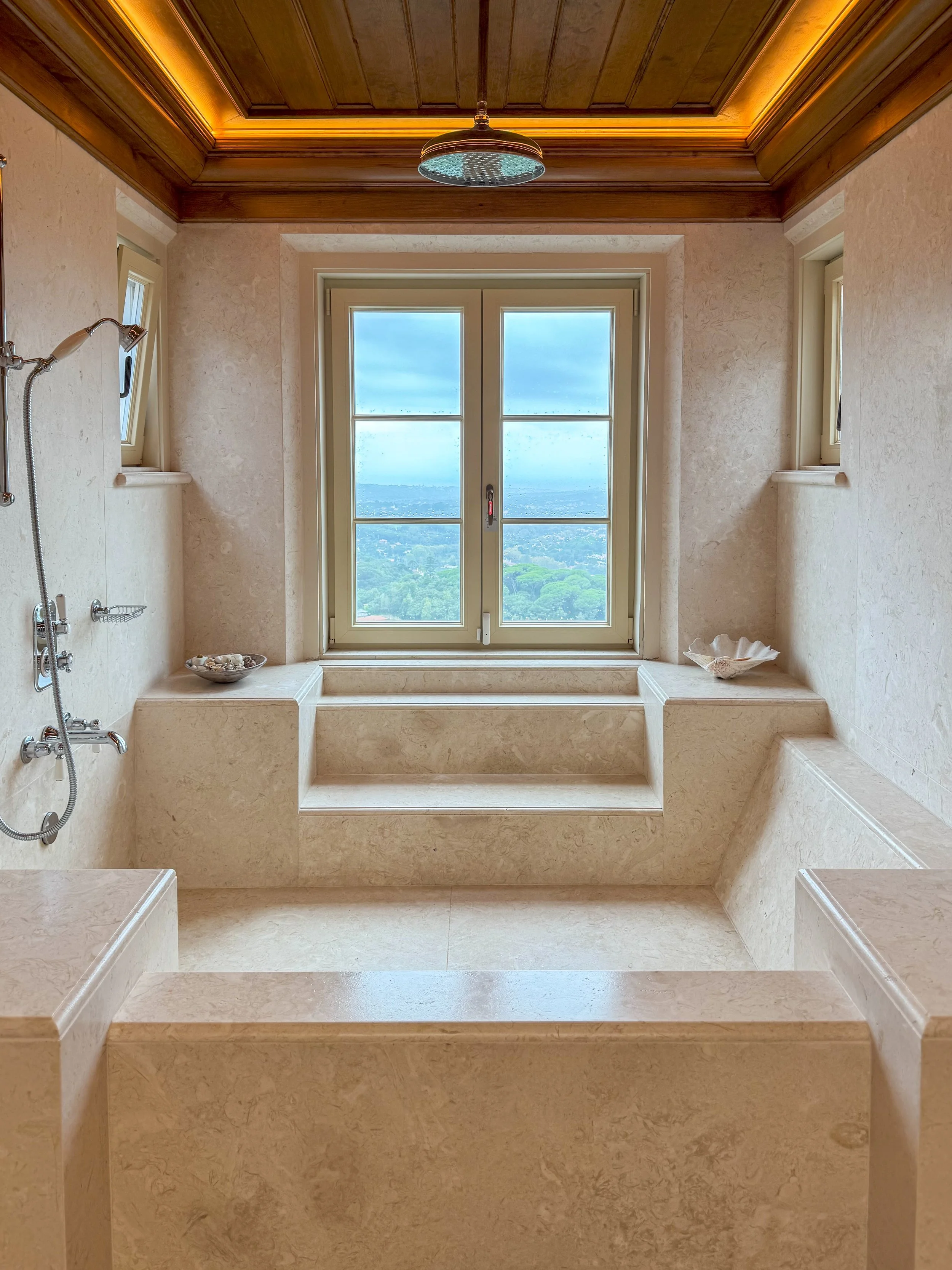 A marble bathroom frames distant Atlantic views through a central window