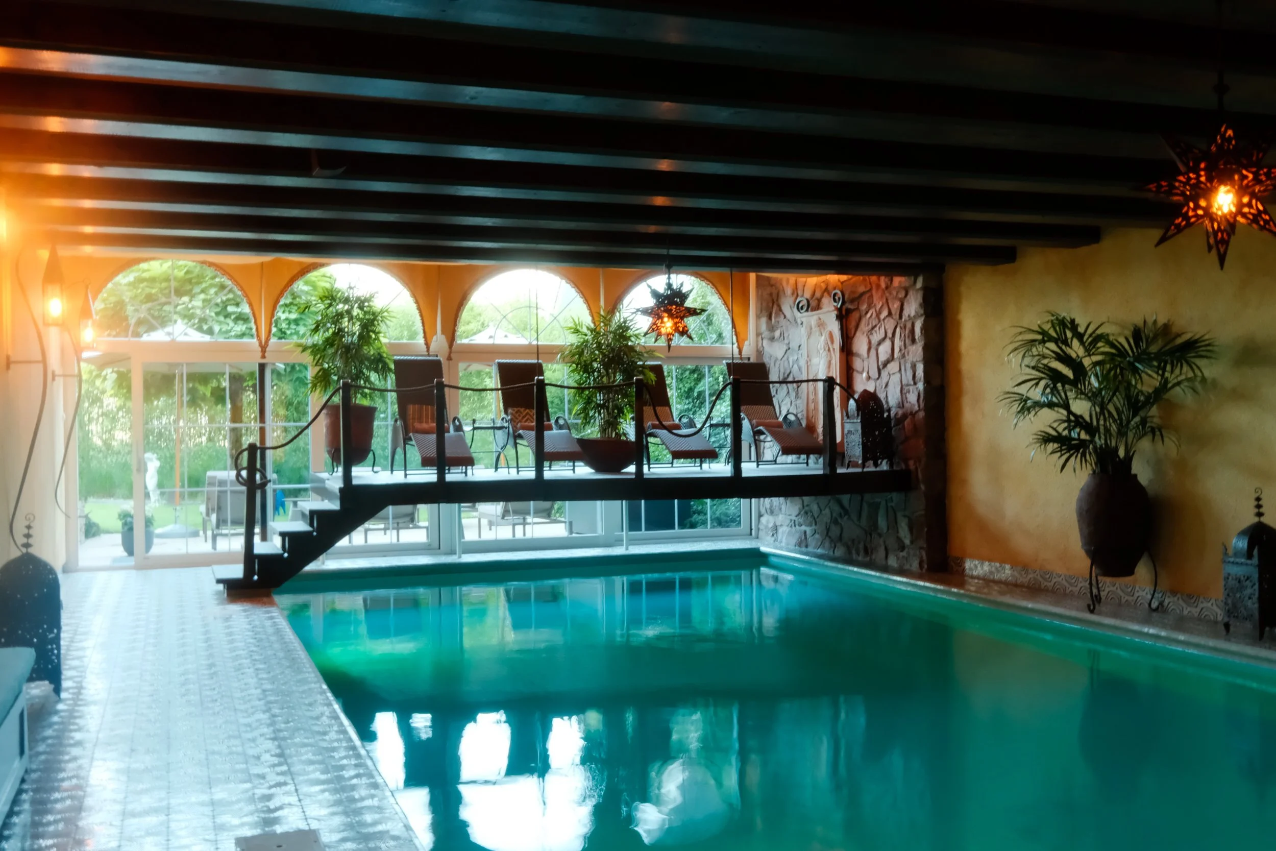 Indoor swimming pool with elegant lounge area and warm ambient lighting