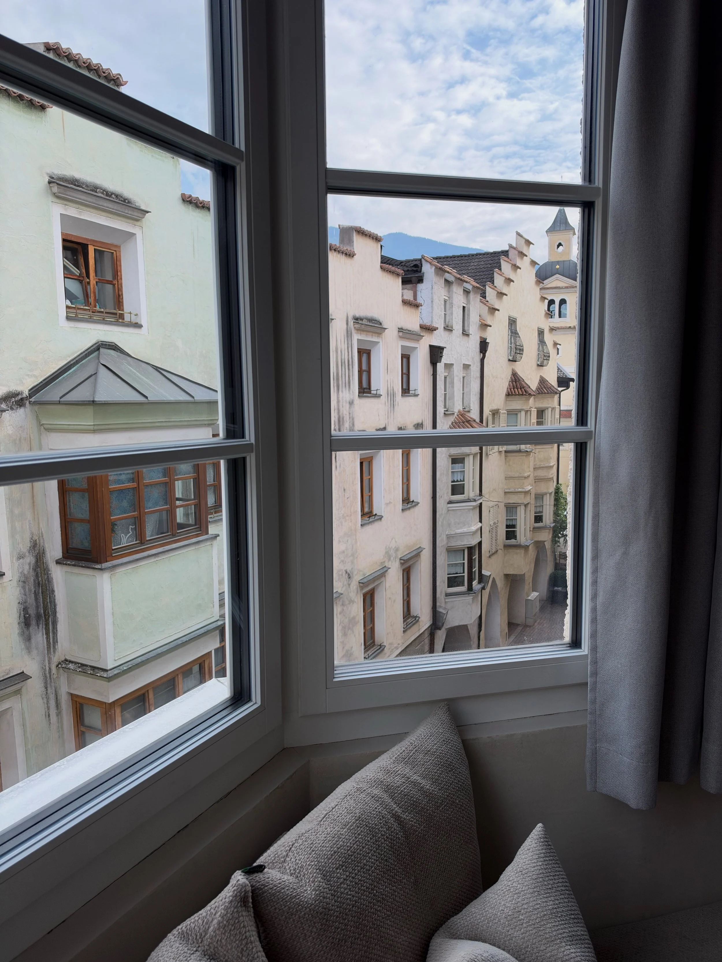 Charming views of Brixen's historic old town through a guest room window, featuring traditional Alpine architecture
