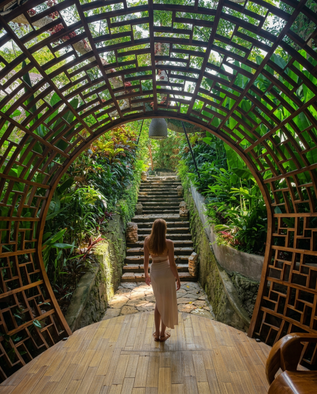 A landscaped garden pathway framed by sculptural bamboo design leads guests through the resort’s lush tropical surroundings