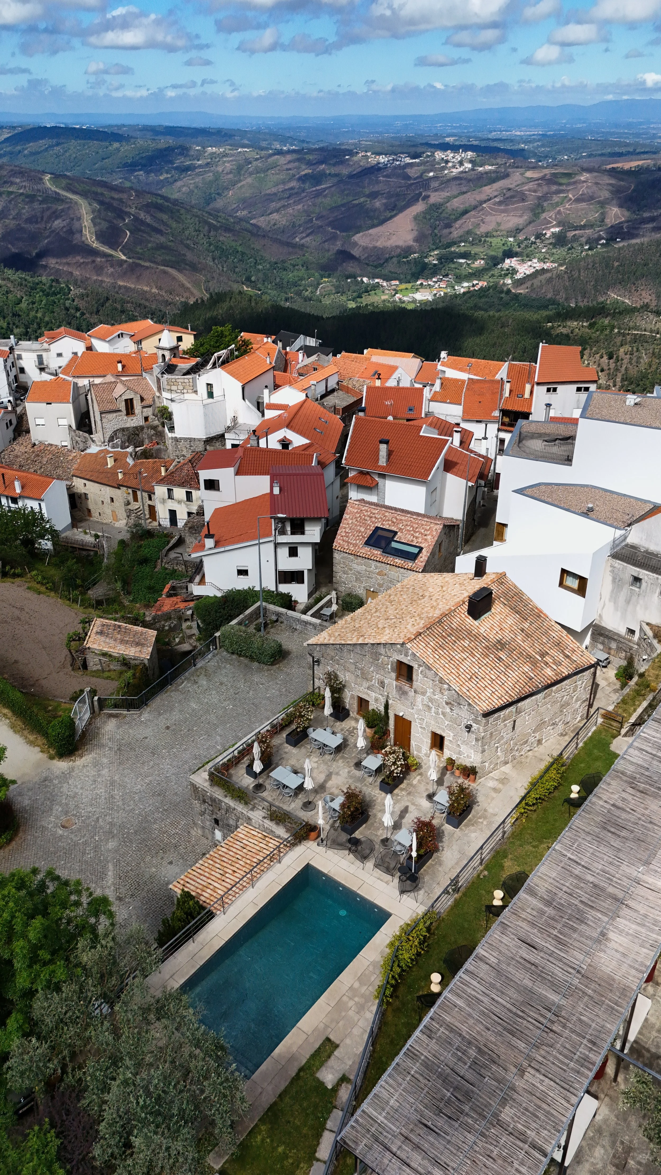 Aerial view of Casas da Lapa village setting with stone houses and mountain landscape in Serra da Estrela, Portugal