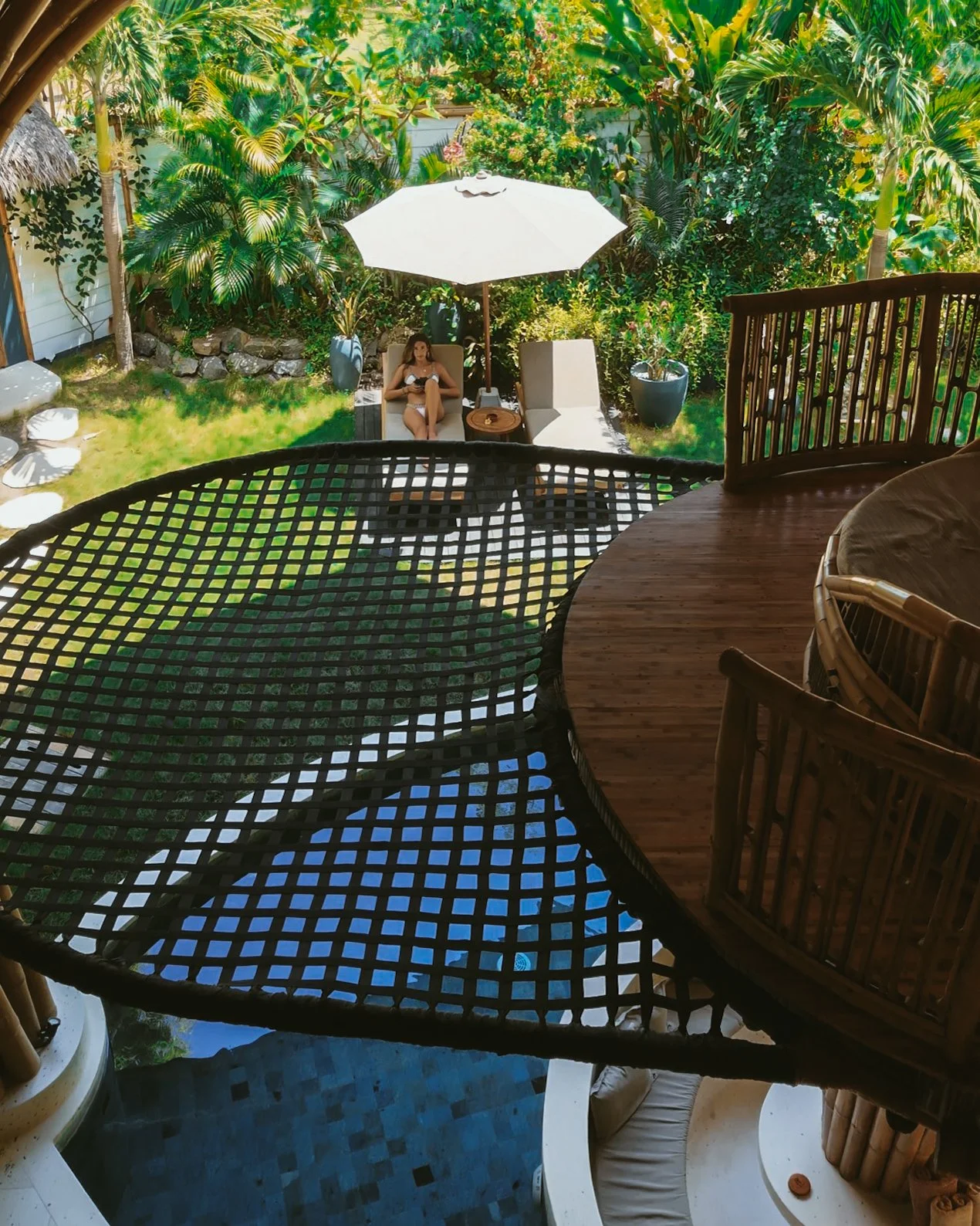 Elevated net lounge overlooking a lush private garden at Villa Tokay, Indonesia