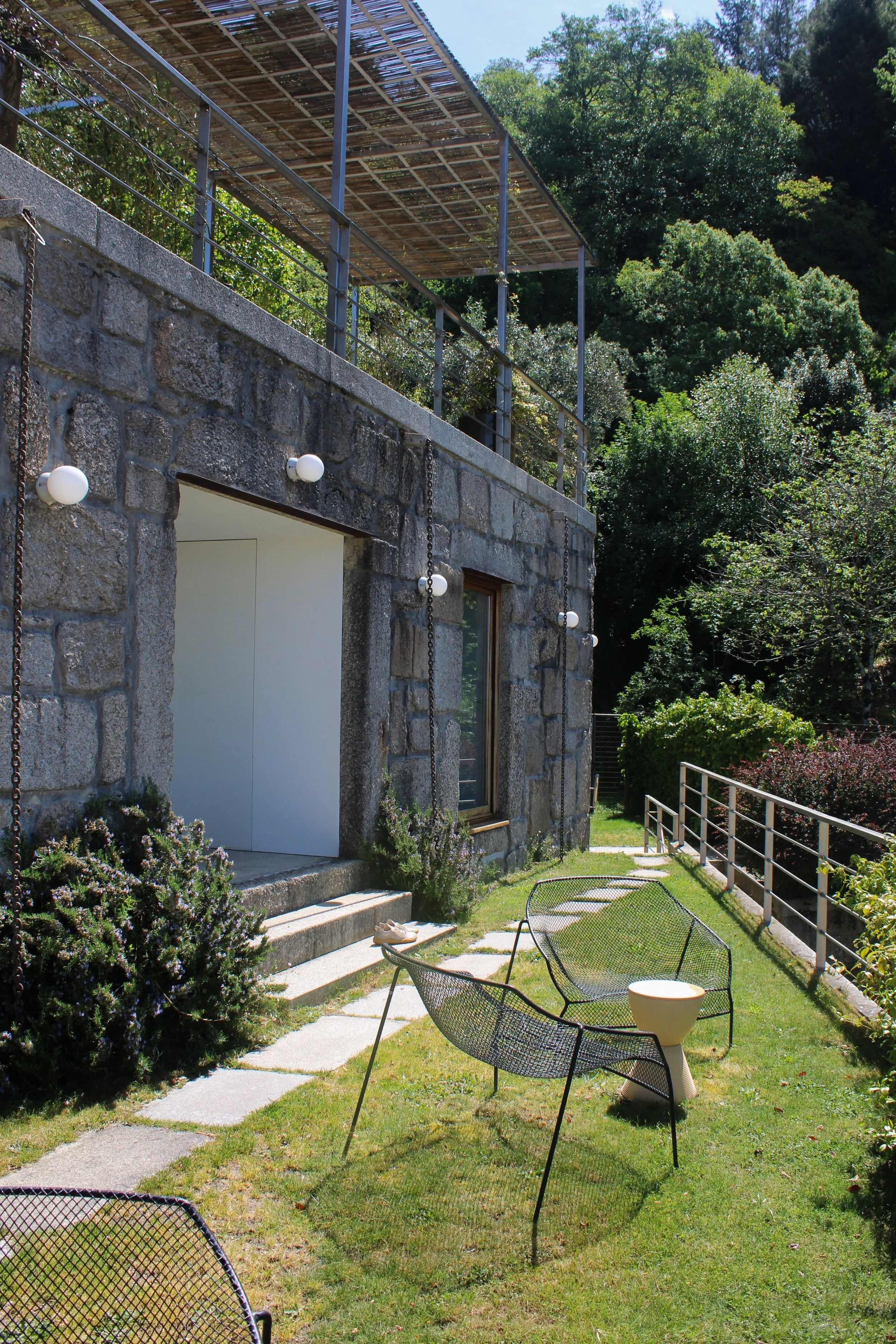 Stone suite exterior with private garden seating and natural surroundings at Casas da Lapa in Serra da Estrela, Portugal