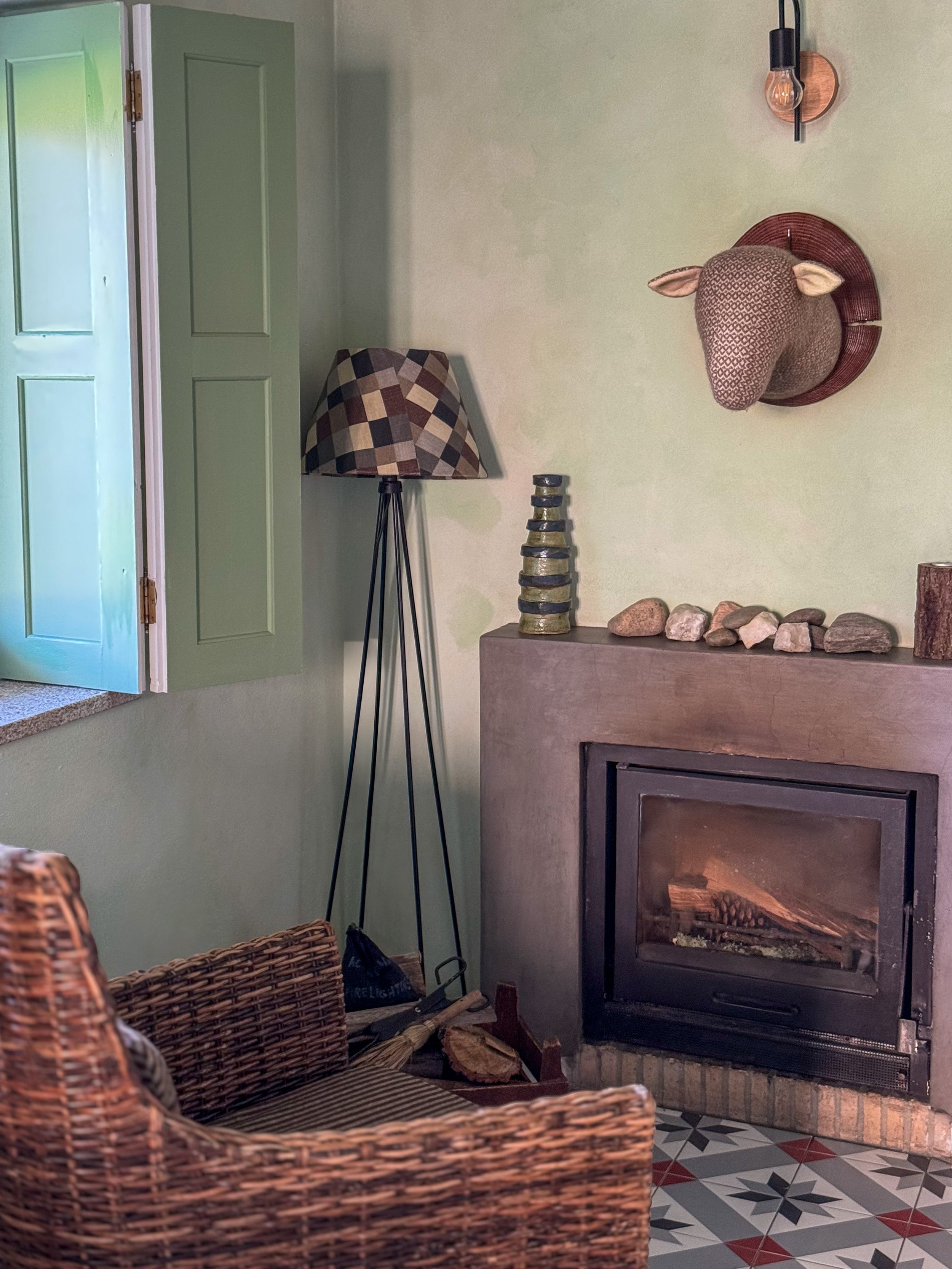 Cozy living room with wood-burning fireplace inside a traditional stone cottage at Chão do Rio