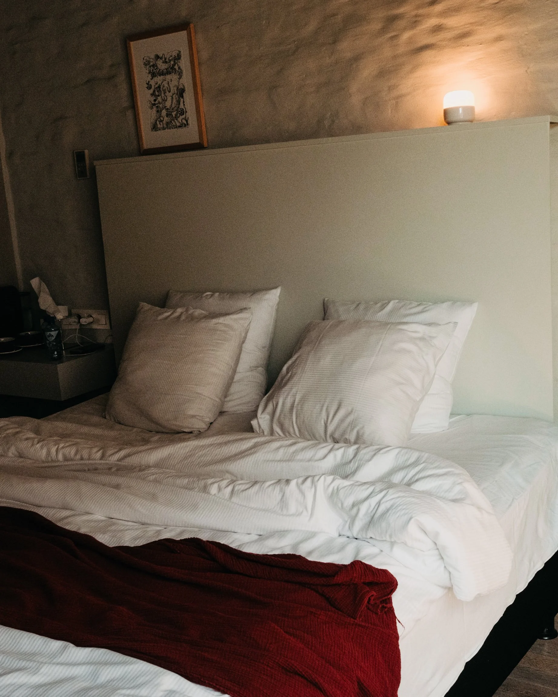 Comfortable king bed with soft linens and warm ambient lighting for a relaxing stay