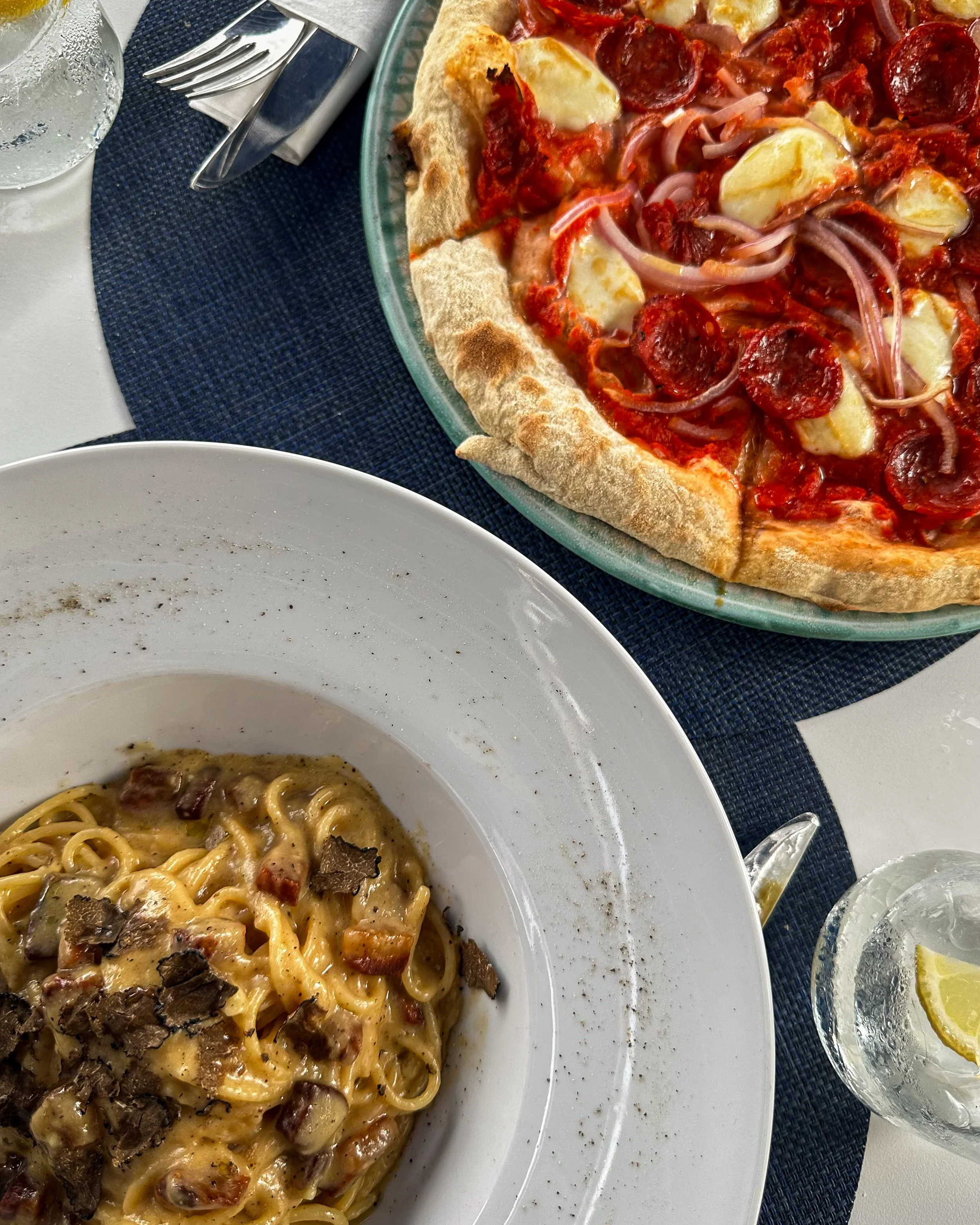 Italian dining experience featuring creamy truffle pasta and freshly baked pizza topped with pepperoni and mozzarella