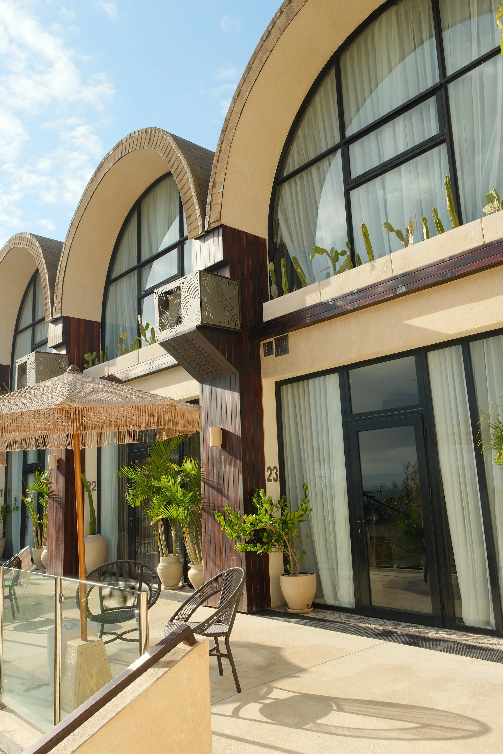Boutique hotel exterior showcasing distinctive curved architecture and private terraces