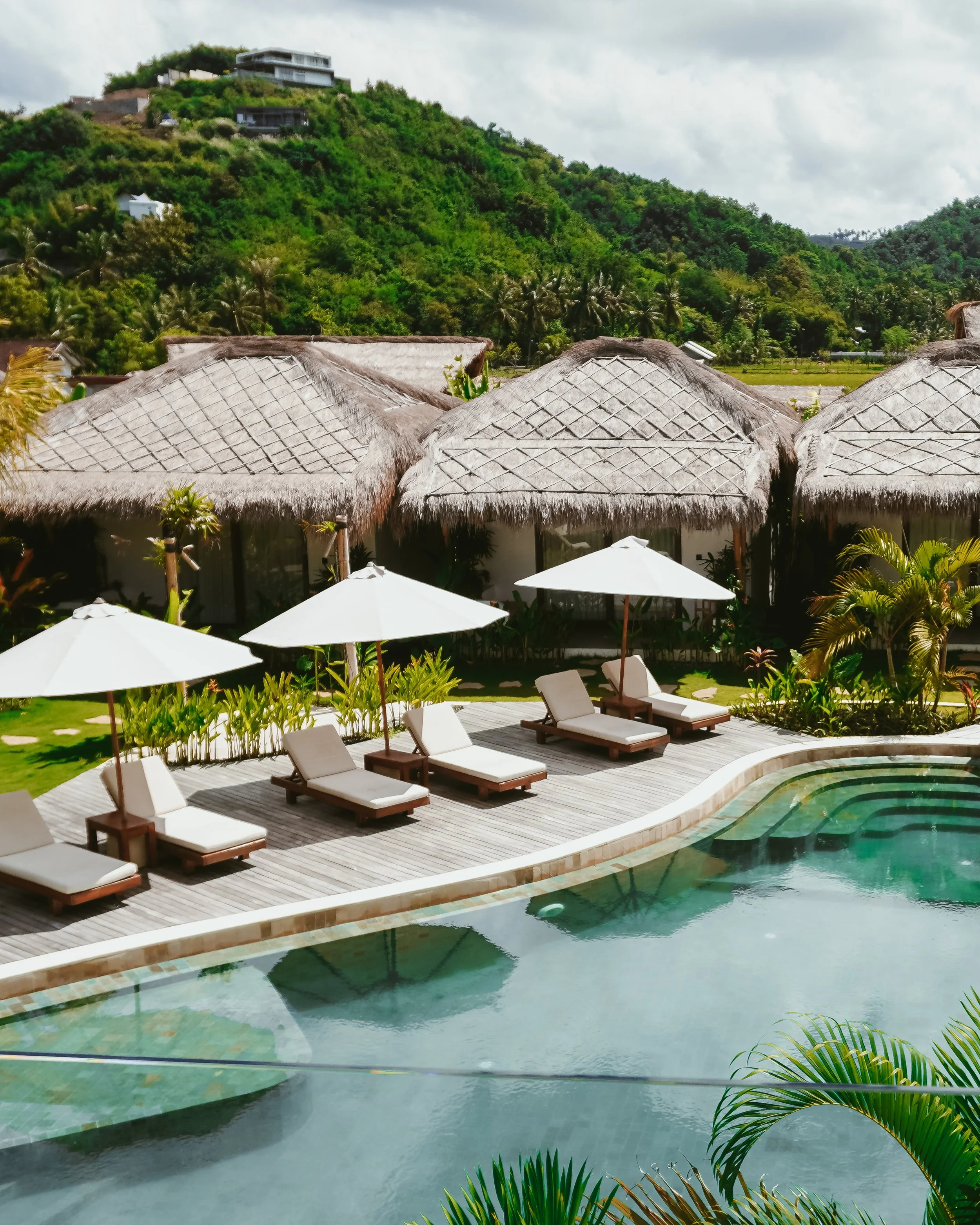 Thatched villas set against lush hills, where tropical simplicity meets quiet luxury, Uryah Hotel Lombok – Lombok, Indonesia.