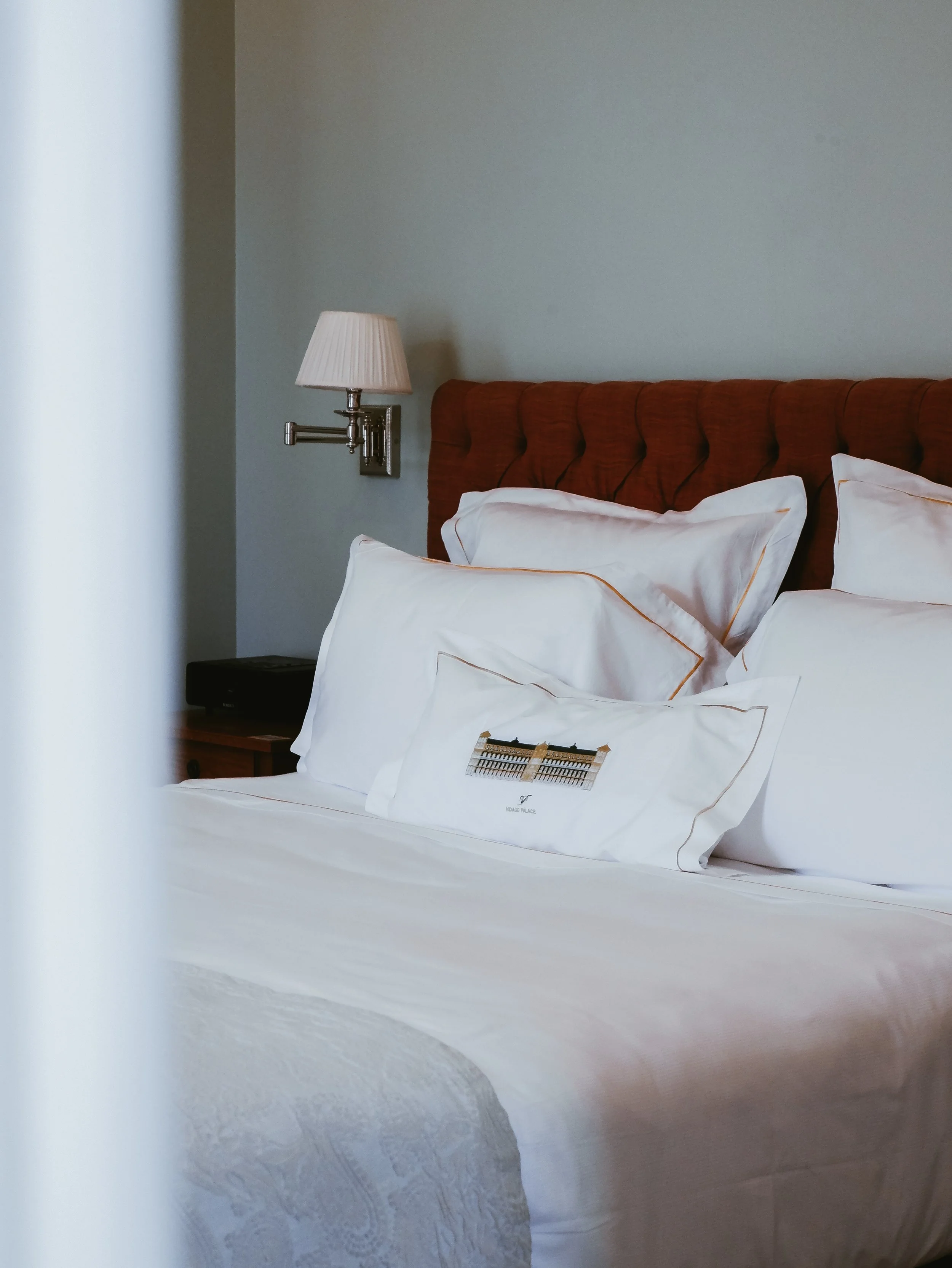 Elegant luxury hotel bedroom with crisp white linens, upholstered headboard, and refined contemporary design