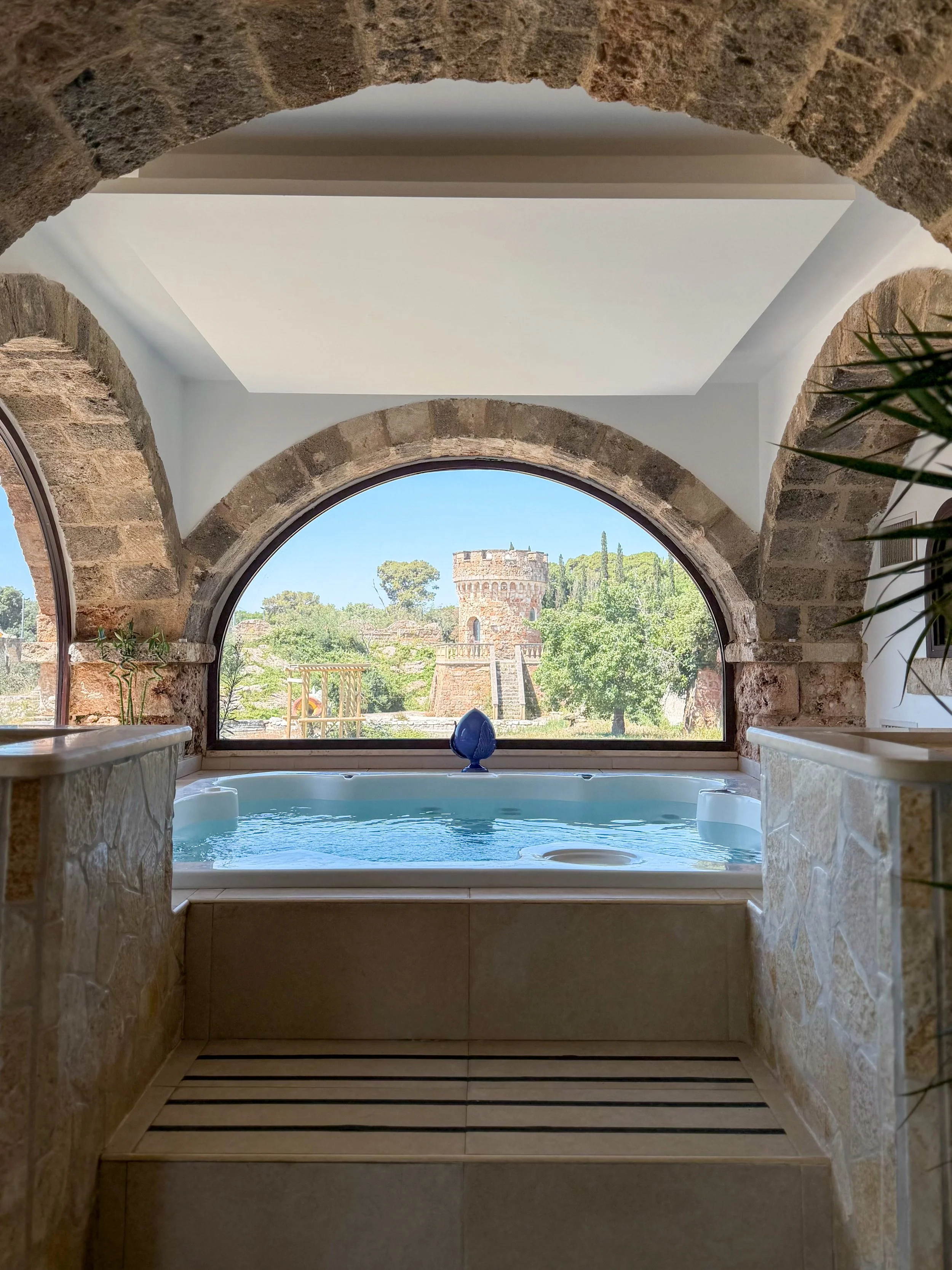 Indoor wellness area with jacuzzi and panoramic views of the estate’s historic towers at Tenute Al Bano