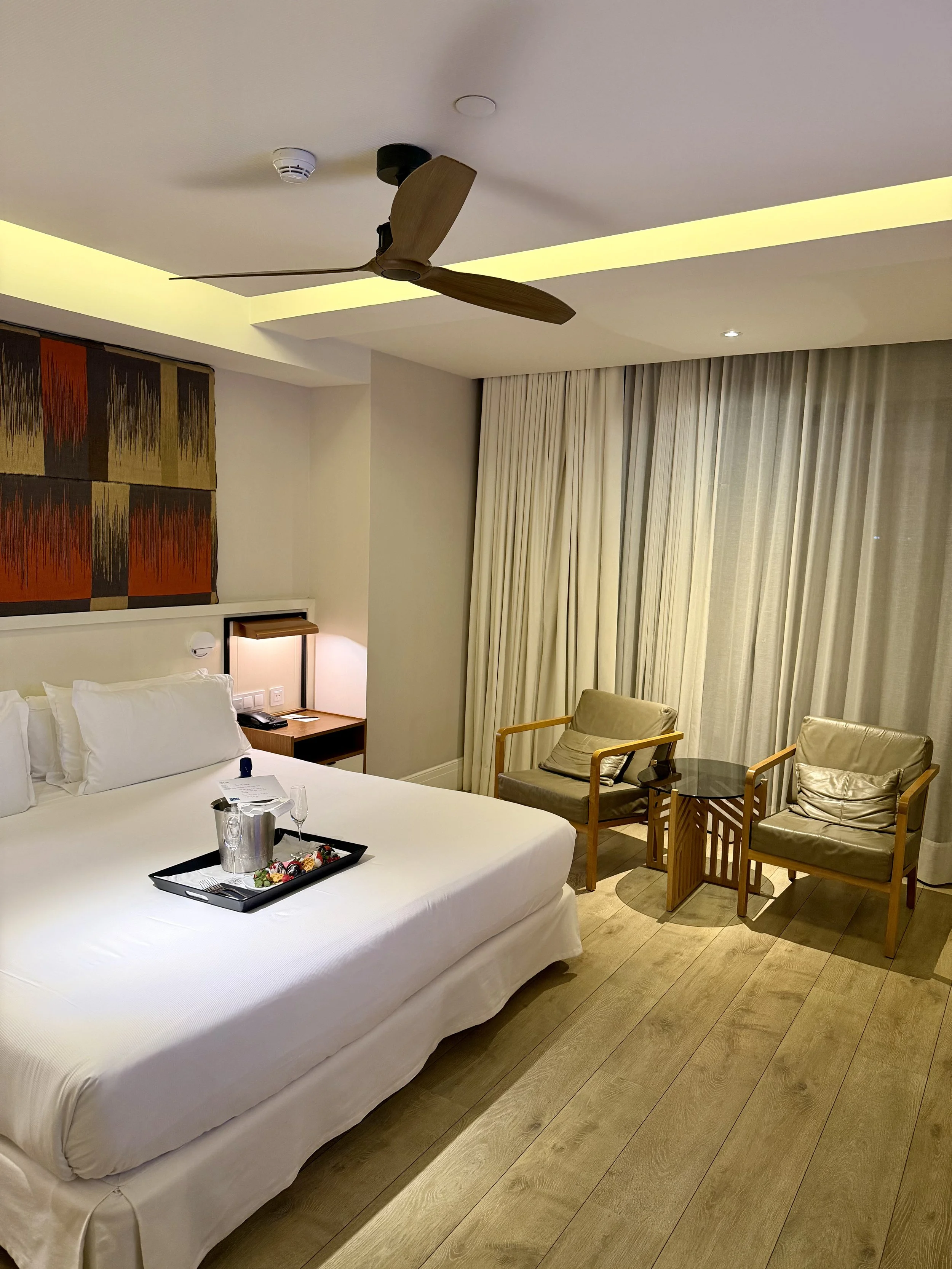 Bright guest room with minimalist interiors, comfortable seating, and floor-to-ceiling windows