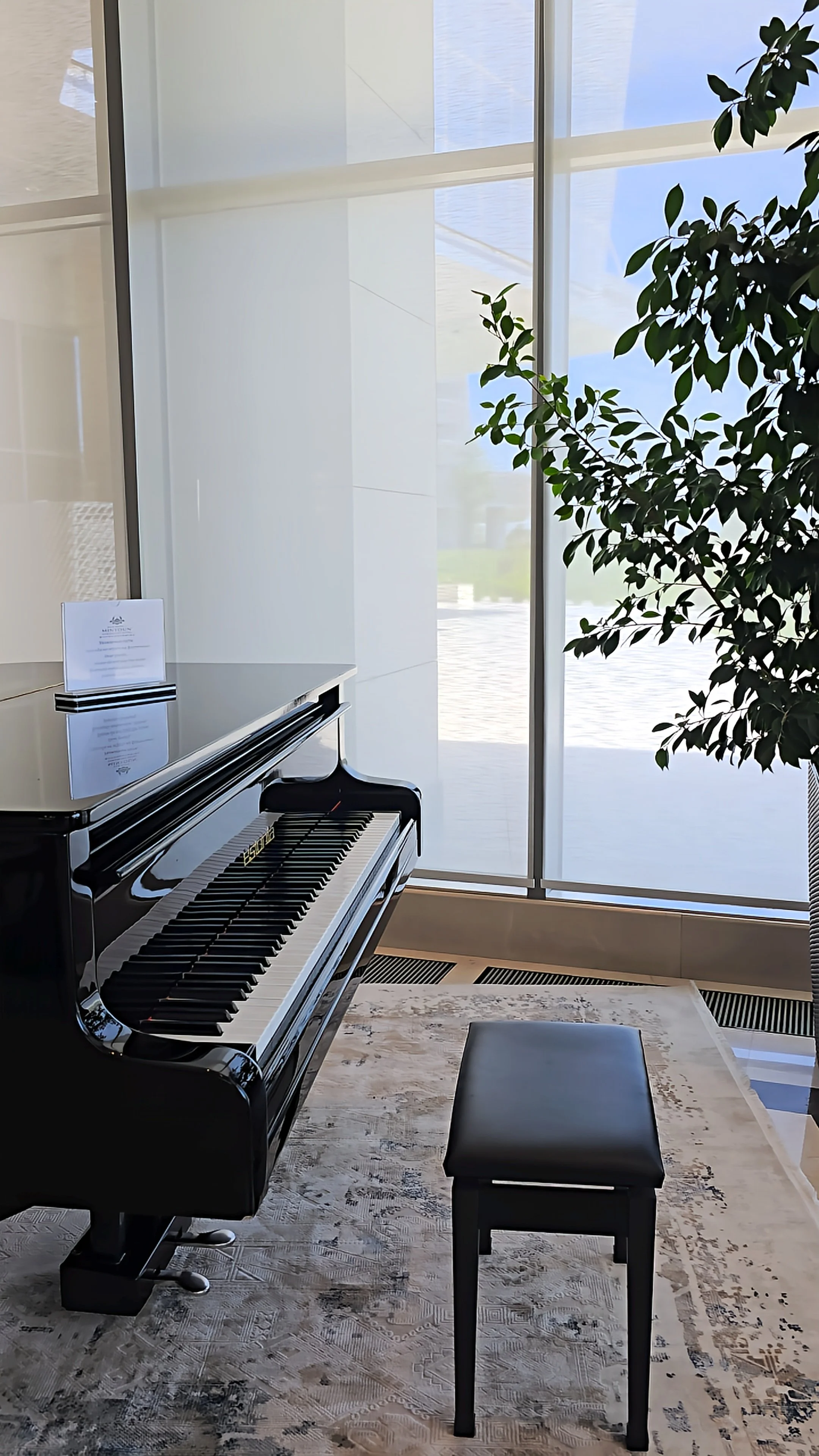 Grand piano displayed inside the elegant hotel lobby filled with natural light and modern design