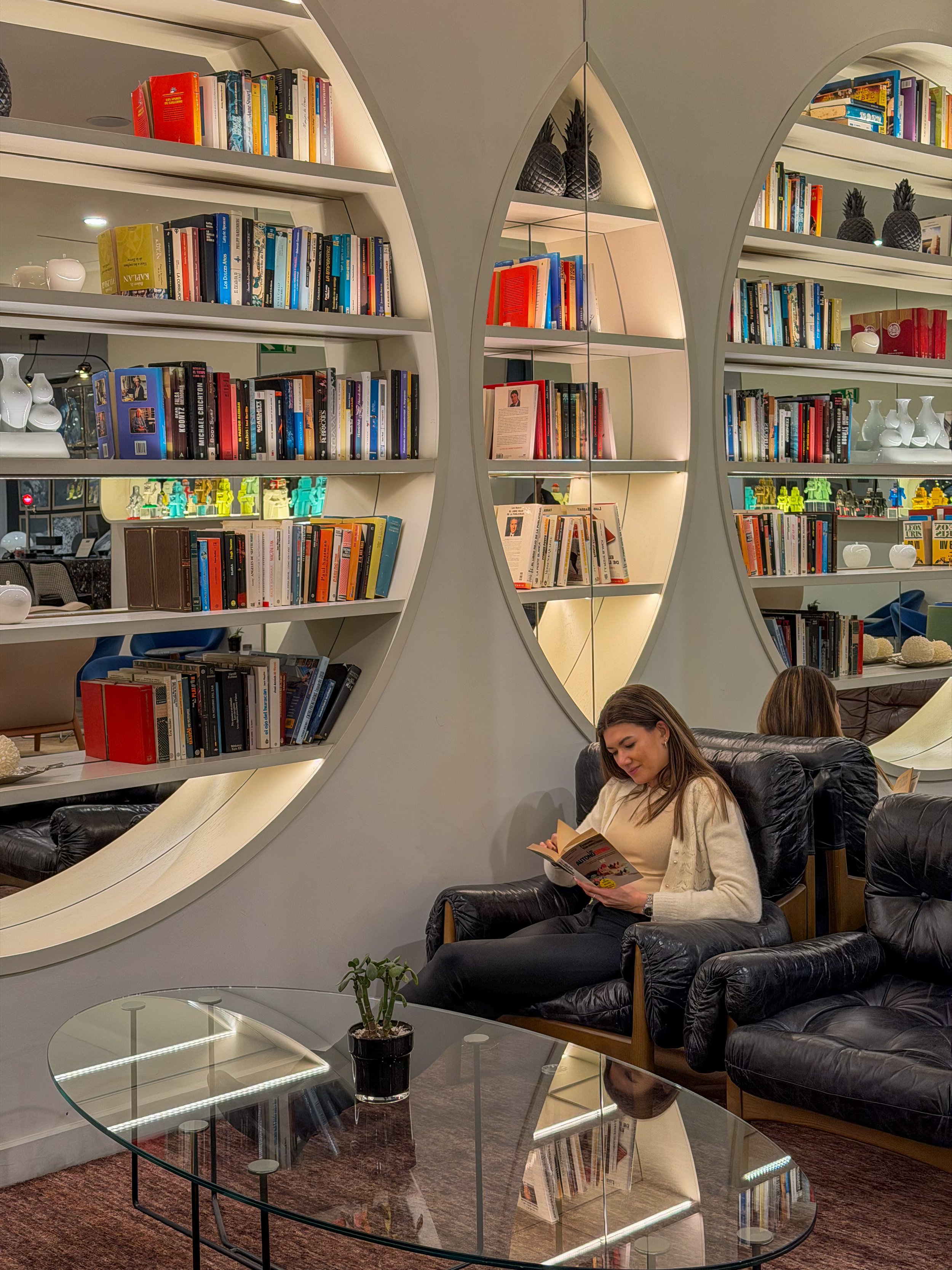 Cozy library lounge with circular bookshelves and inviting reading spaces