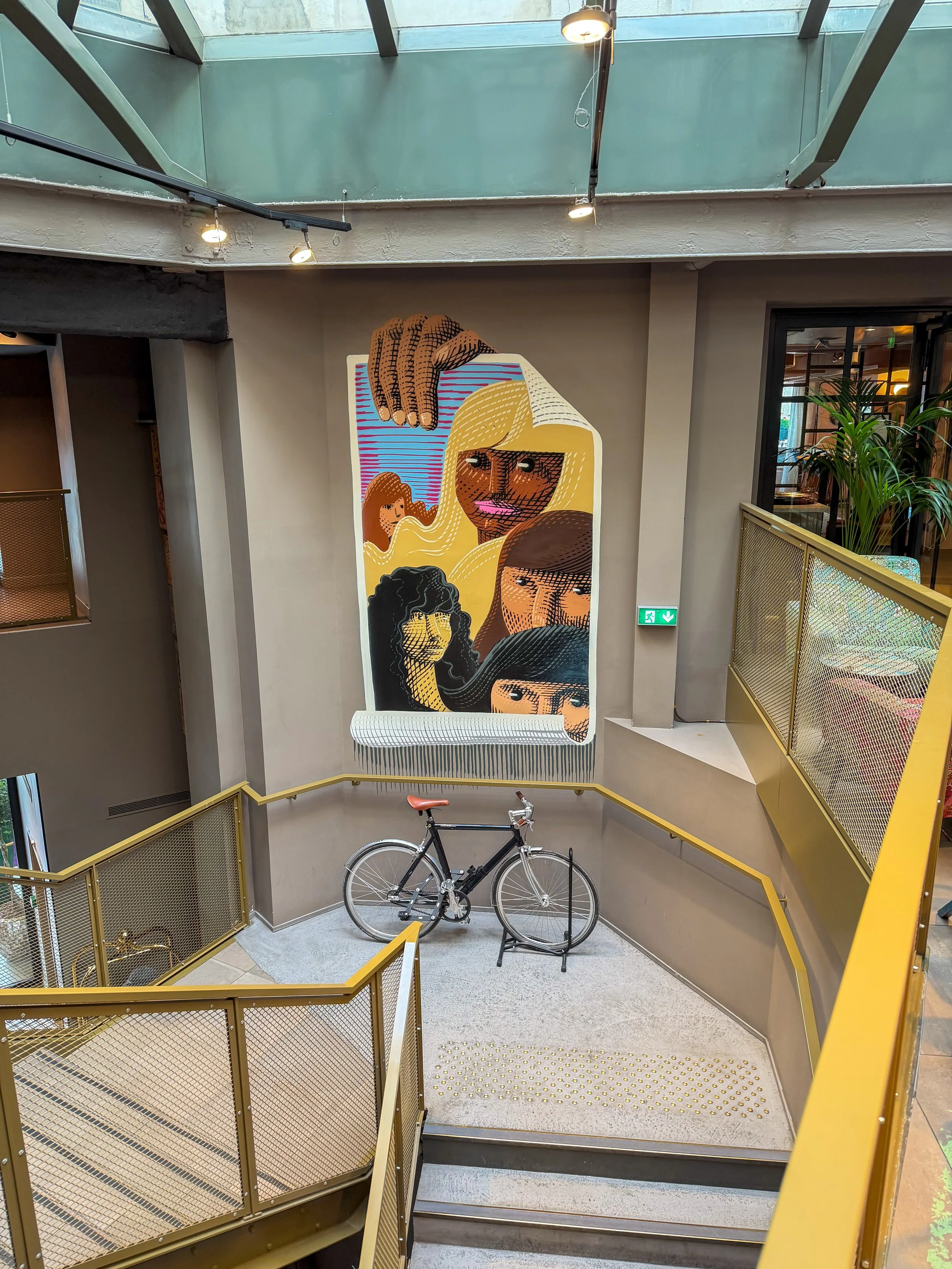 Central staircase showcasing striking contemporary artwork and industrial architecture