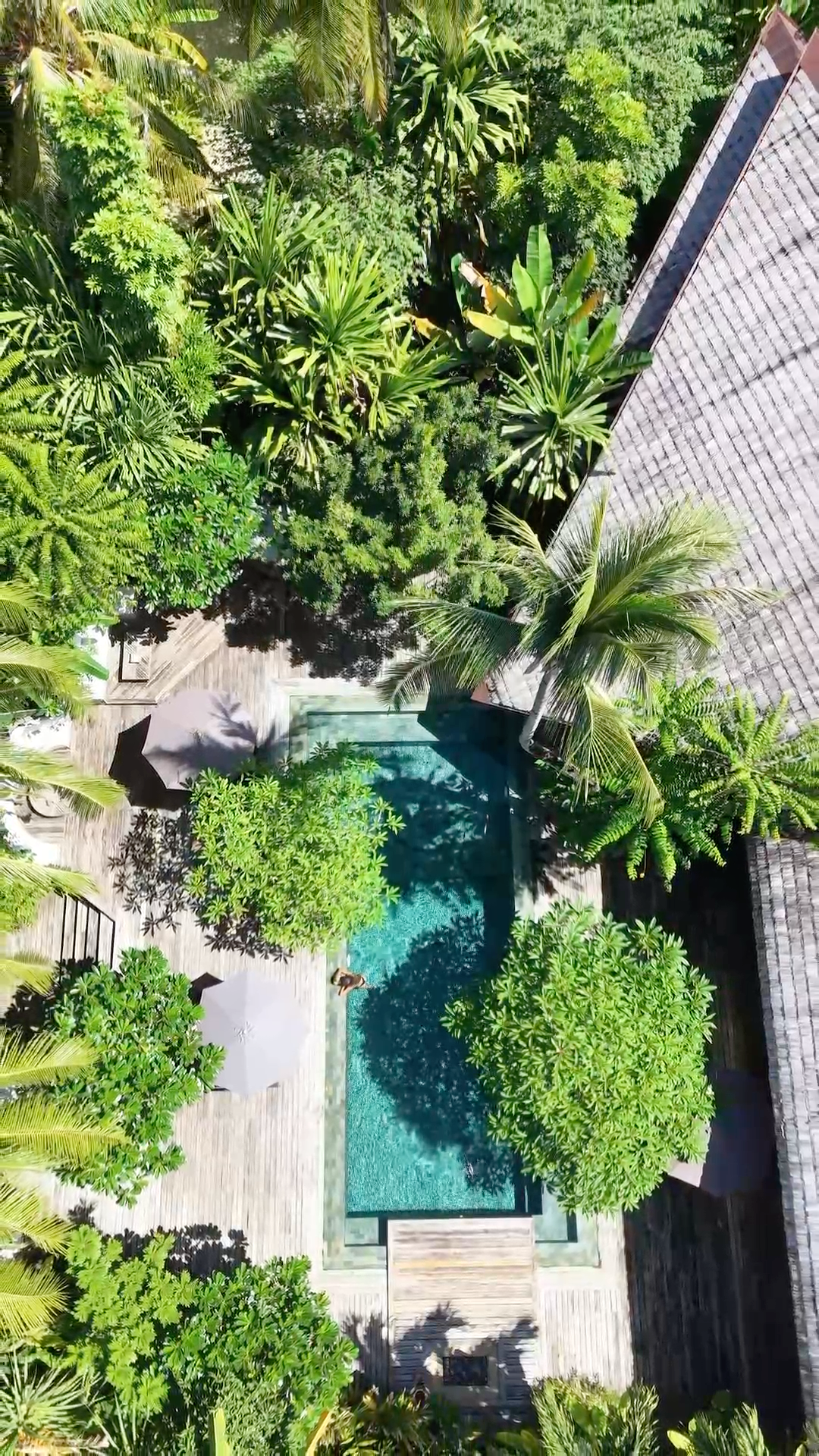 Drone view showcasing the tropical villas nestled among lush gardens and the resort pool