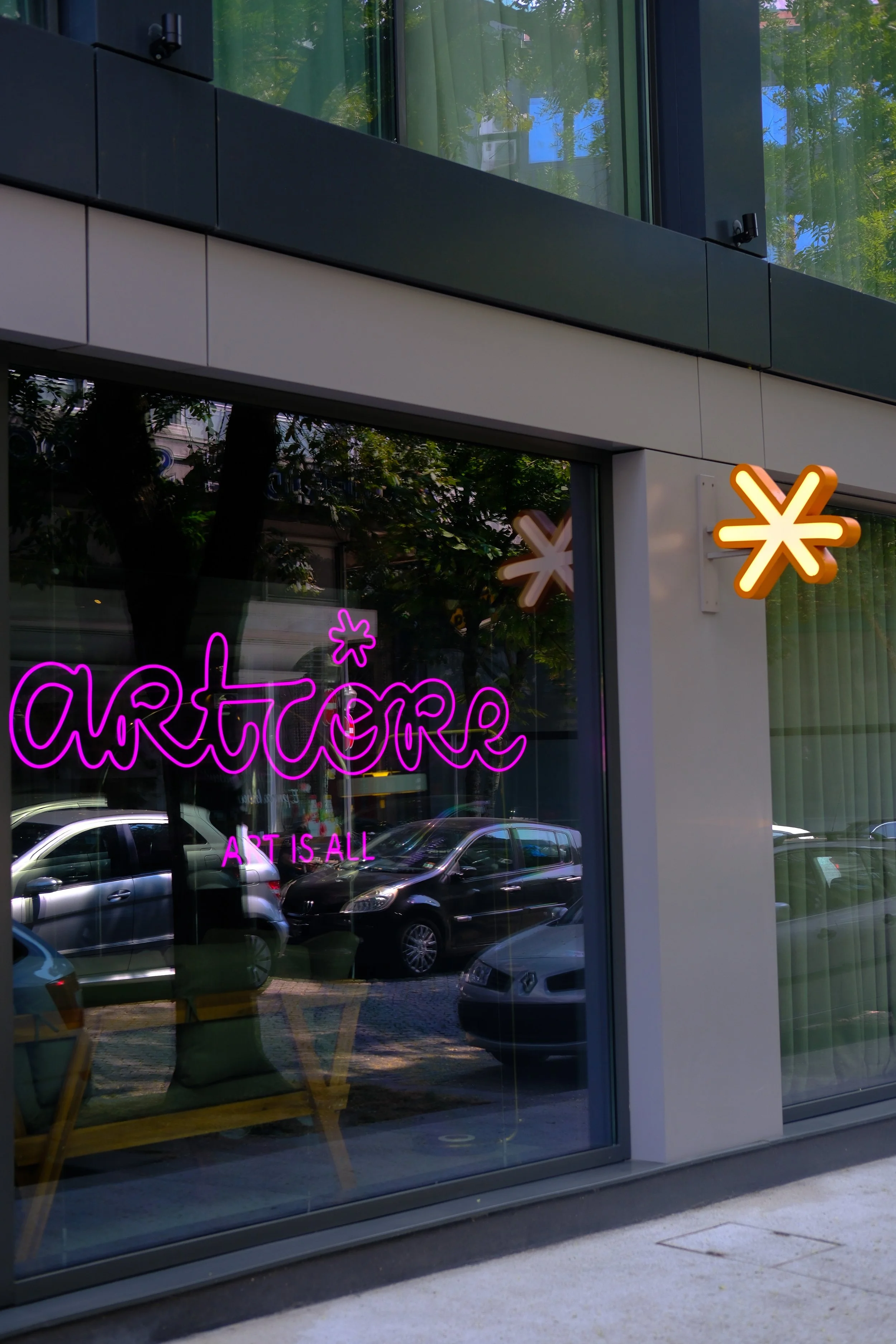 Modern hotel façade with artistic neon signage welcoming guests in central Porto