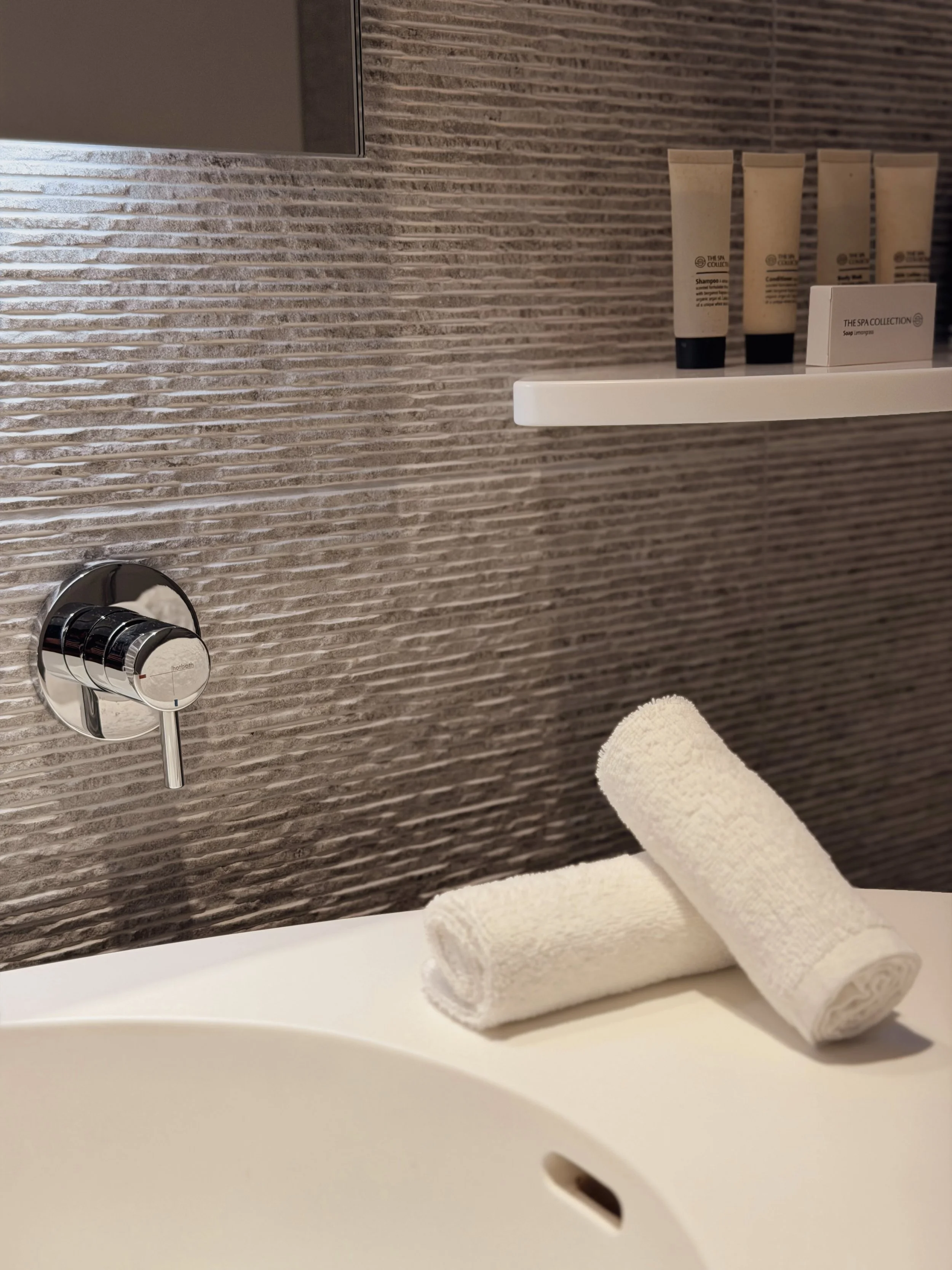 Modern bathroom amenities with luxury toiletries and fresh towels